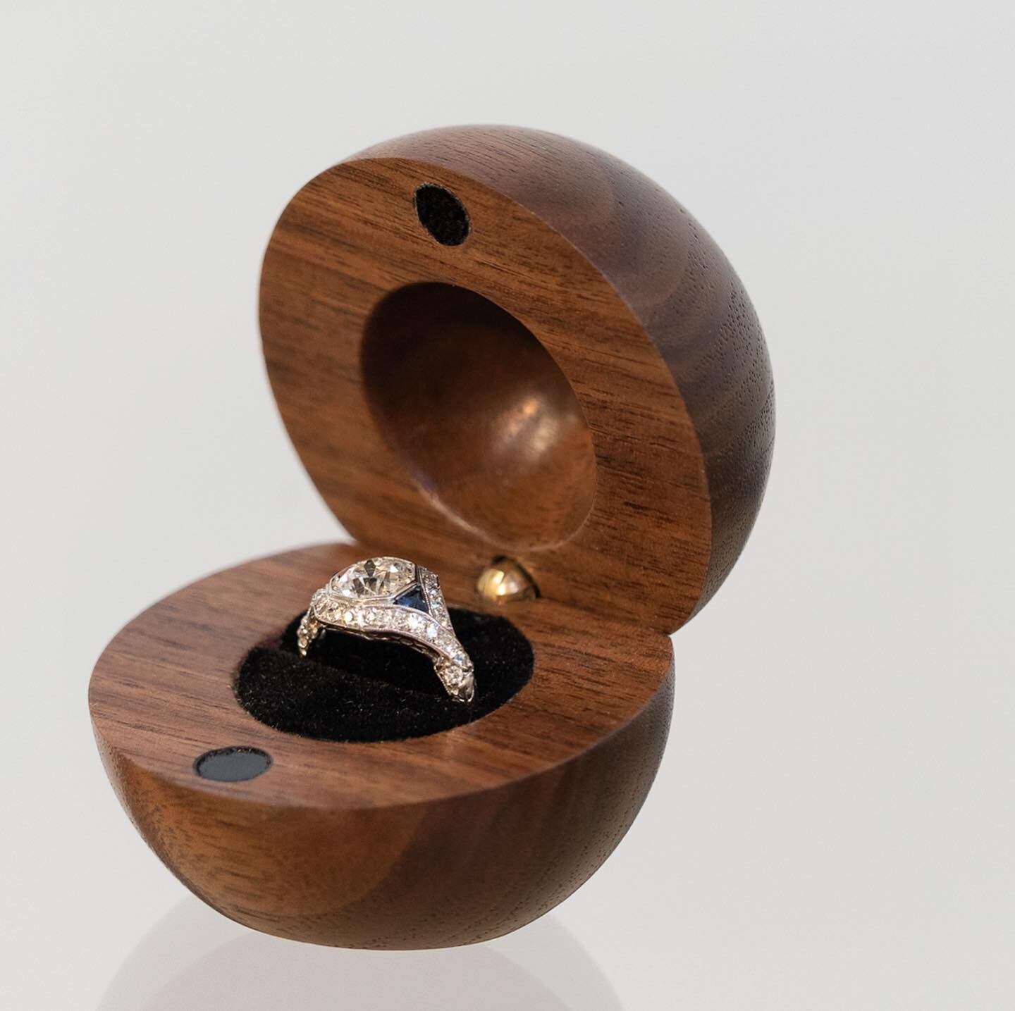 This was an unexpected and unconventional request, but we made it happen.

A friend of mine wanted a spherical ring case for his proposal out of a solid piece of walnut. This was turned after being halved, with the hinge and ring slot already in plac
