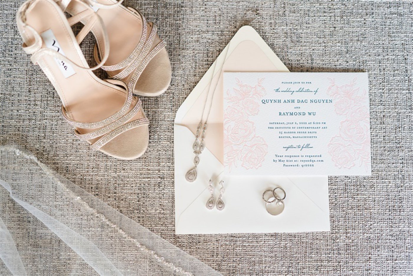 Flat lay of a white and blue wedding invitation with blush flowers