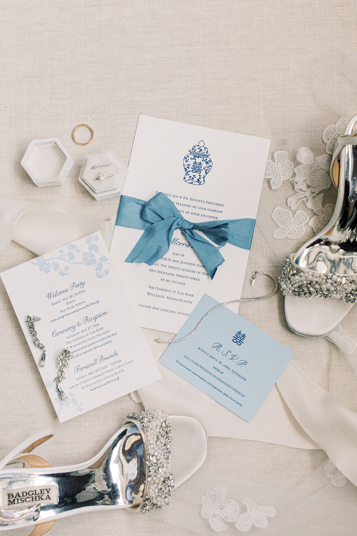 Flatlay of a chinoiserie wedding invitation with silver Badgley Mischka bridal shoes