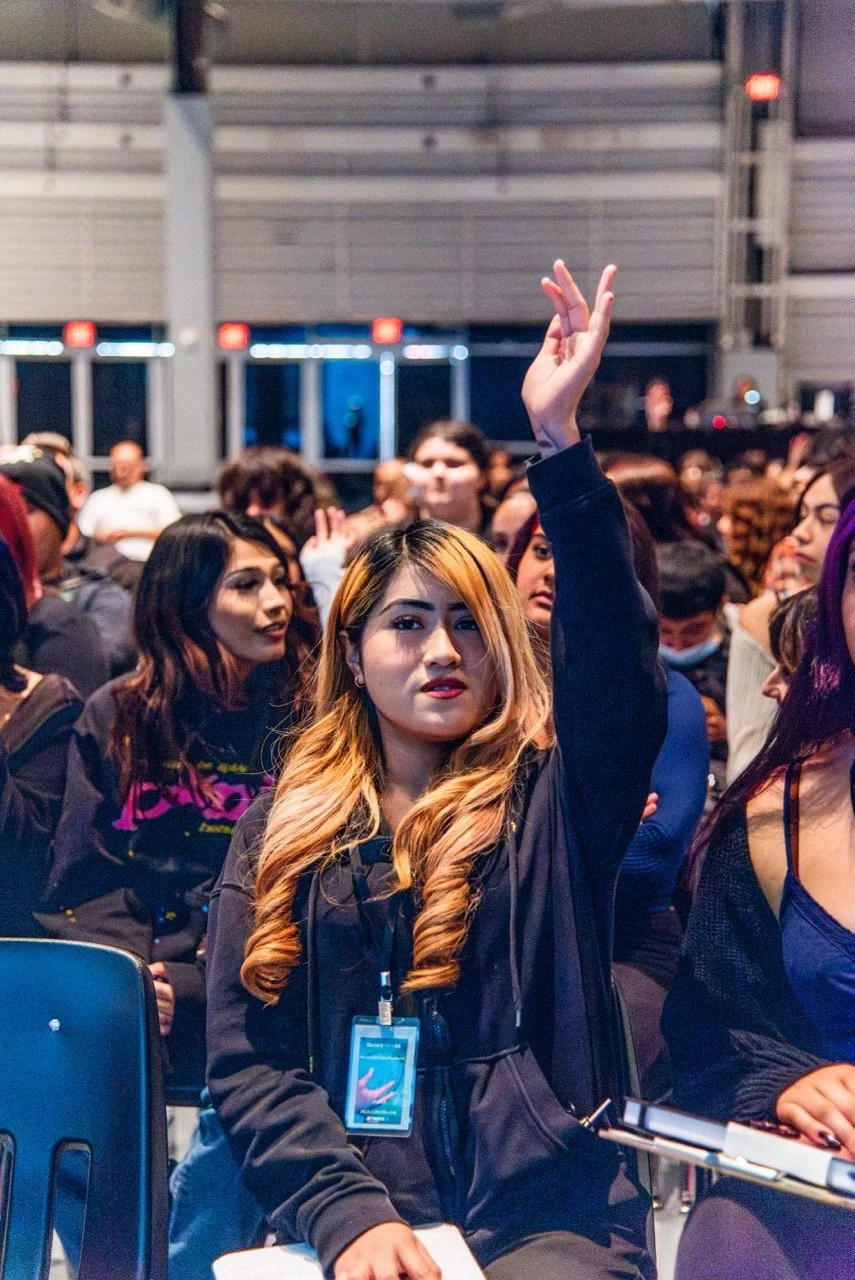 A Jack London student raises her hand to answer trivia about the MONUMENTS exhibition.  (Photo credit: Fabiola Lopez)