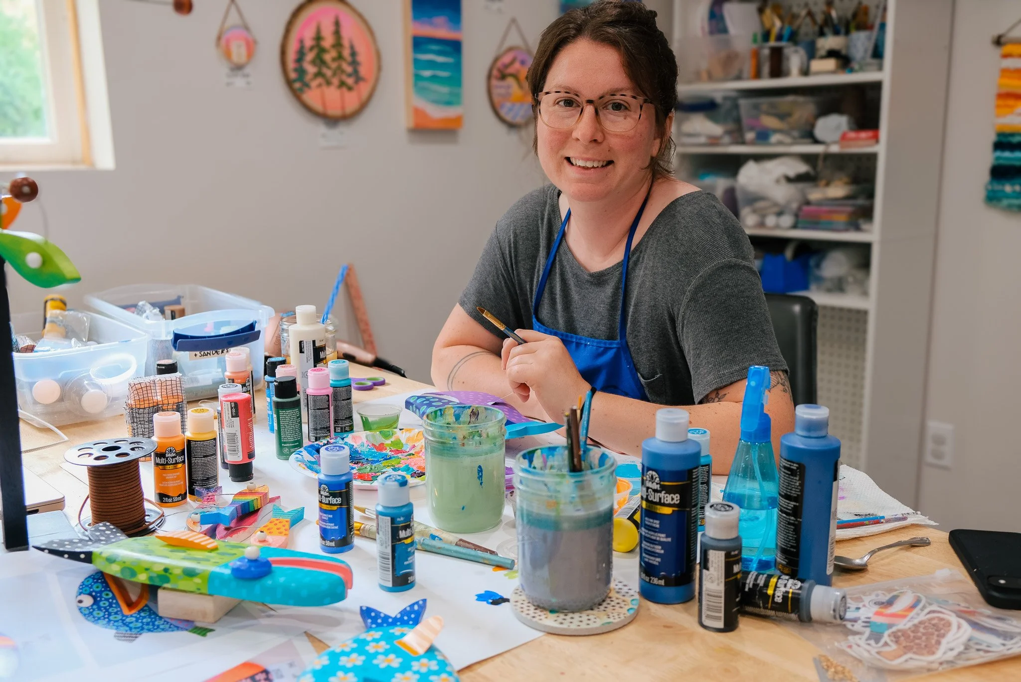 Kirstie Drews of Echo Foxx Design, painting fish in Traverse City Michigan, whimsical wood fish