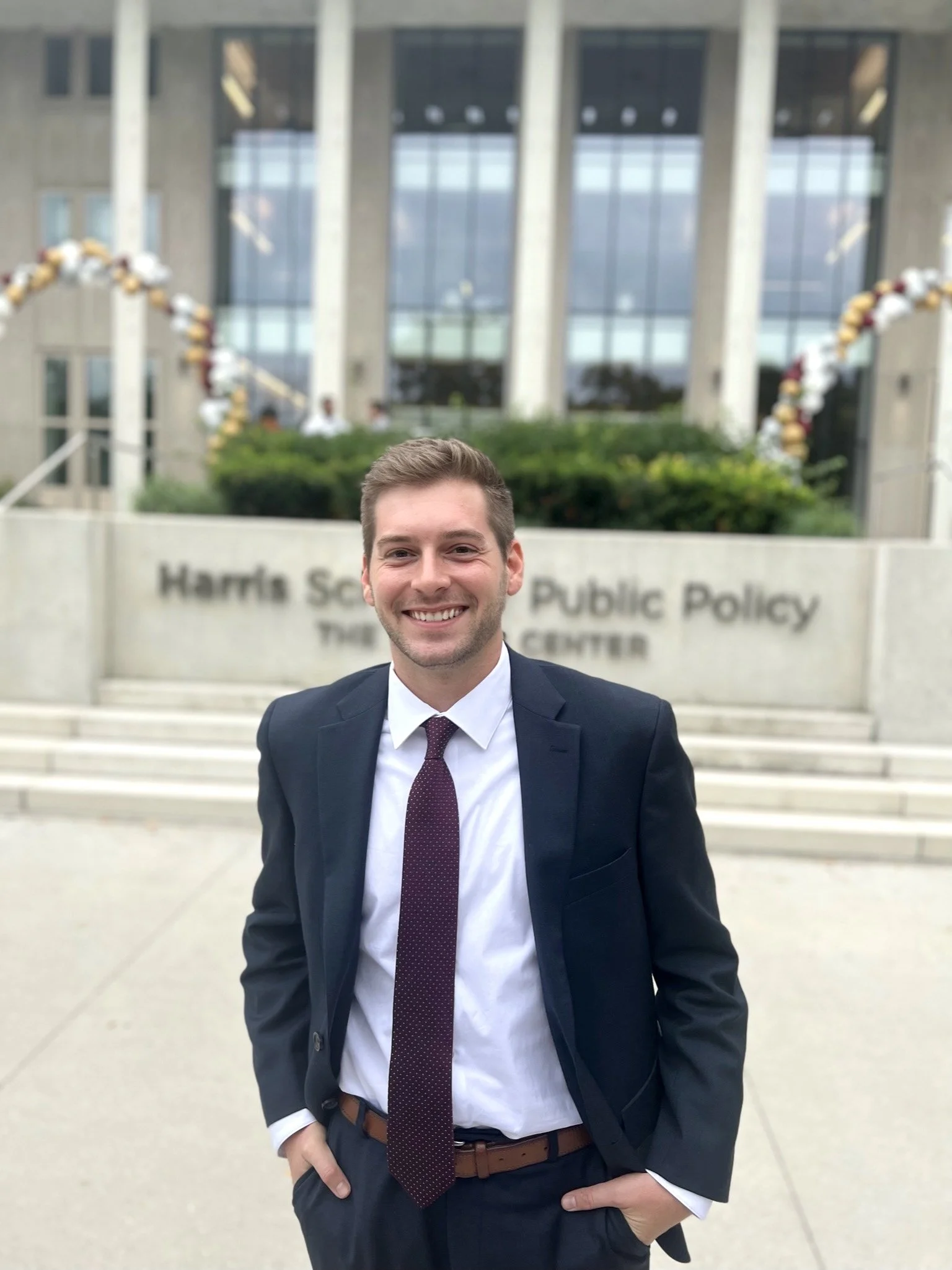 Alexander Battaglia, MPP, Associate at M. Palmer Consulting standing outside the Harris School of Public Policy