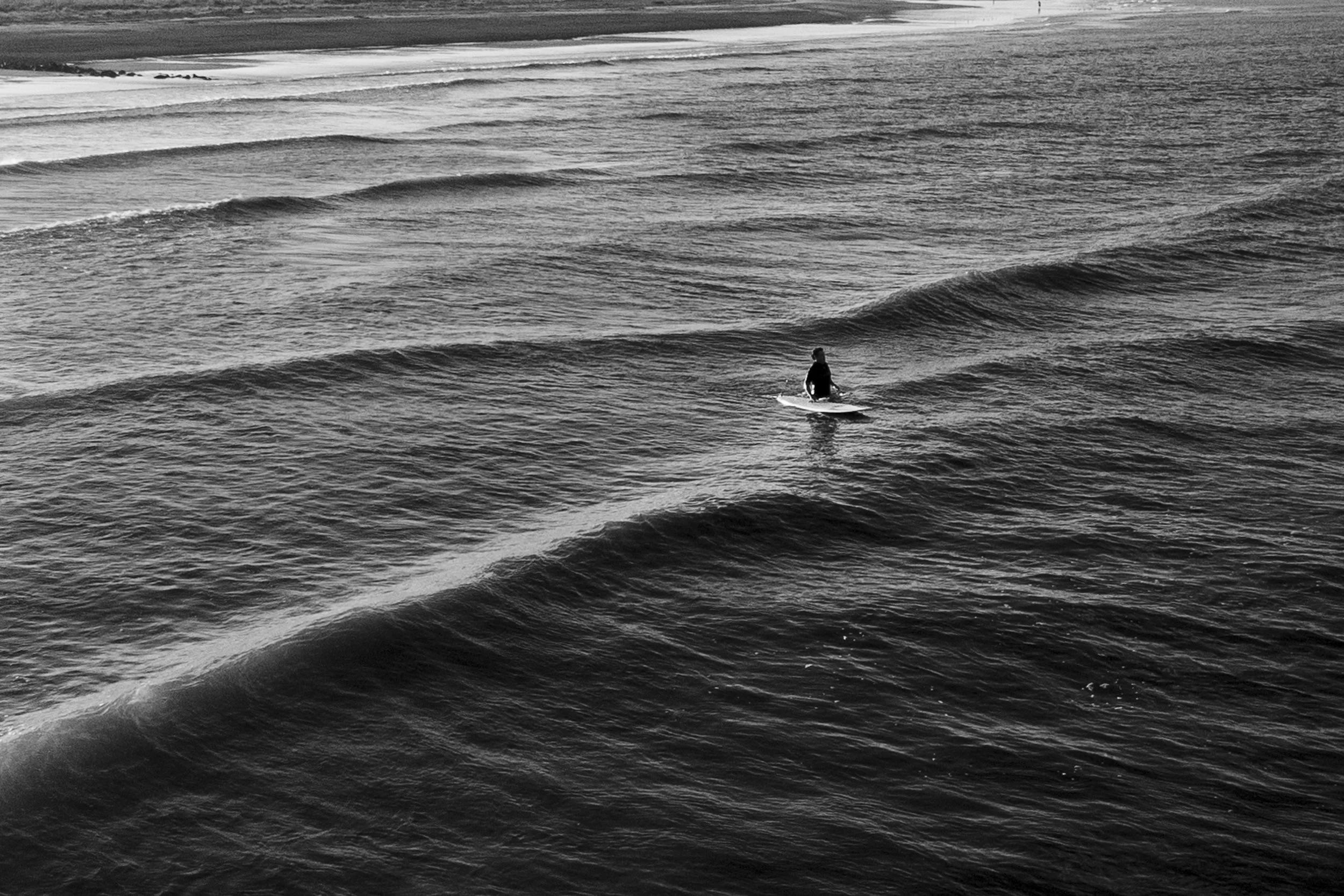On October 30, 2023, a single surfer wades into the water during a less crowded session in the evening at Tybee Island.
