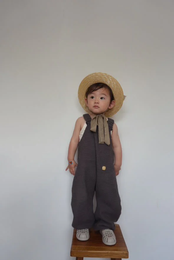 child wearing organic cotton waffle pullover dungarees charcoal, sun hat, scarf