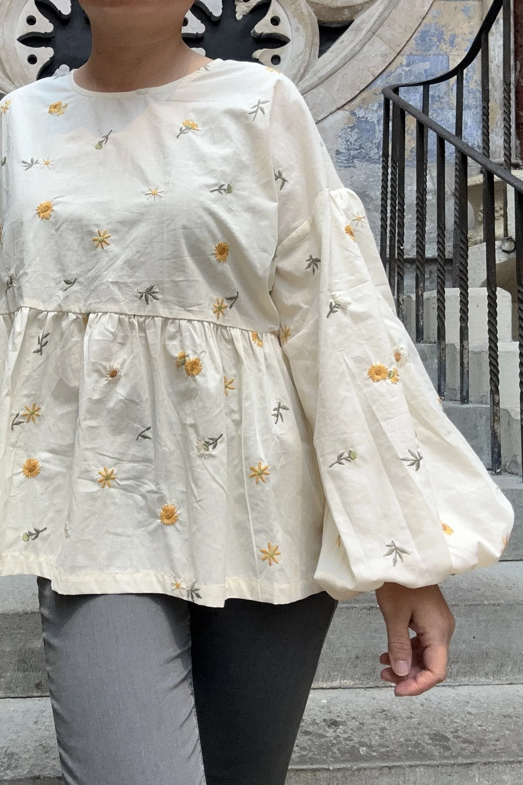 Adult wearing embroidered dandelions Top, Featuring a relaxed fit, balloon sleeves, paired with grey skinny jeans