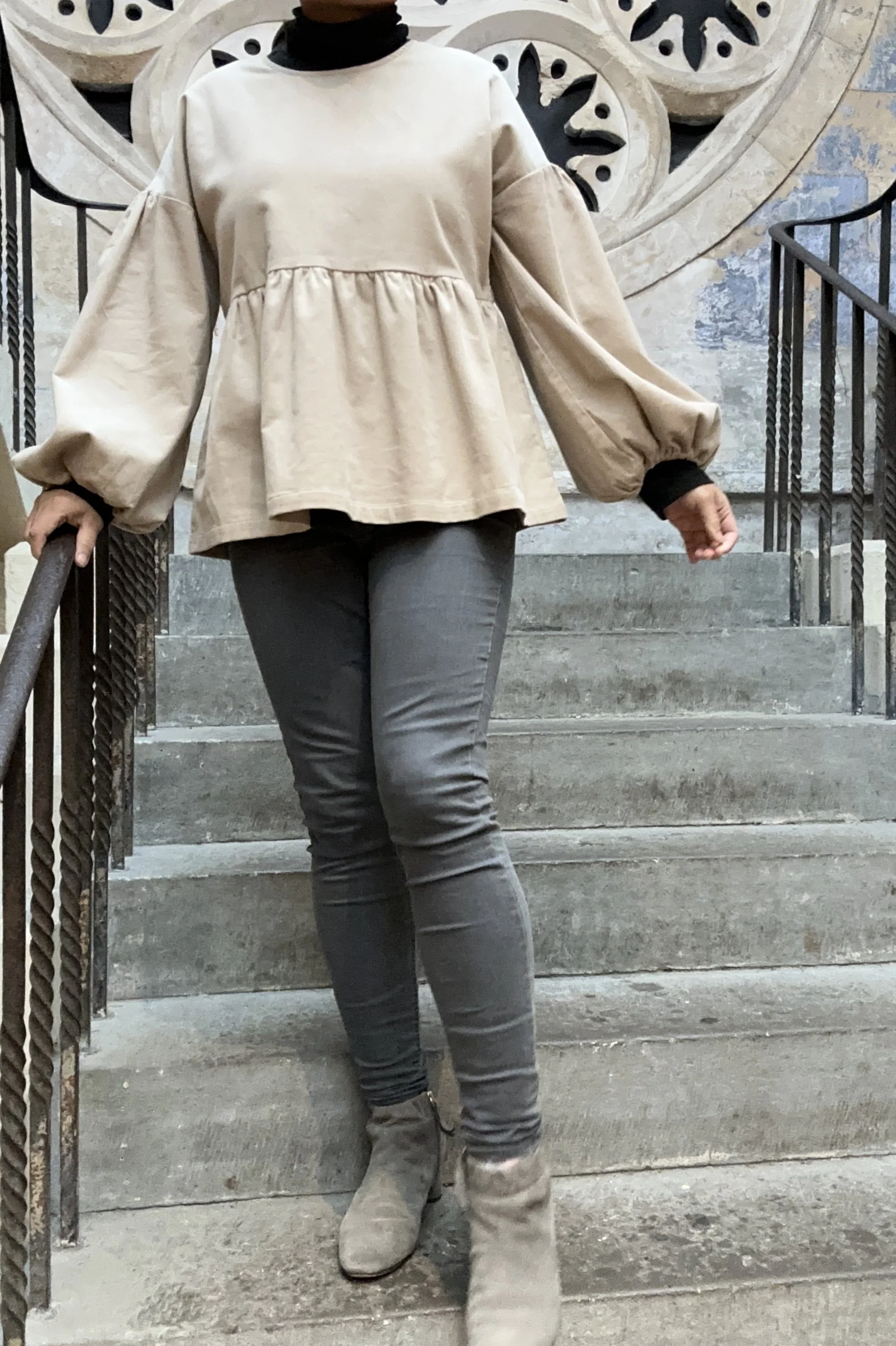 Adult wearing Latte Corduroy Top, Featuring a relaxed fit, balloon sleeves, paired with grey skinny jeans, and grey boots