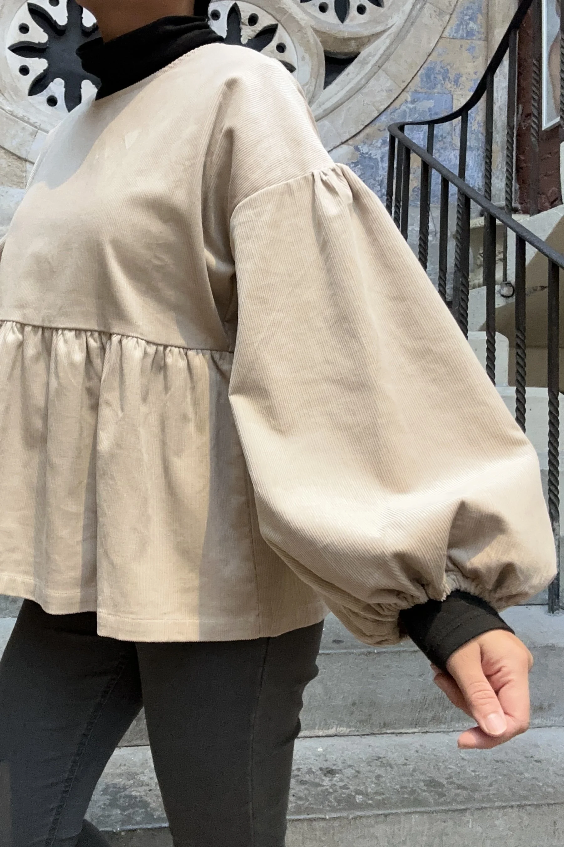 Adult wearing Latte Corduroy Top, Featuring a relaxed fit, balloon sleeves, paired with grey skinny jeans