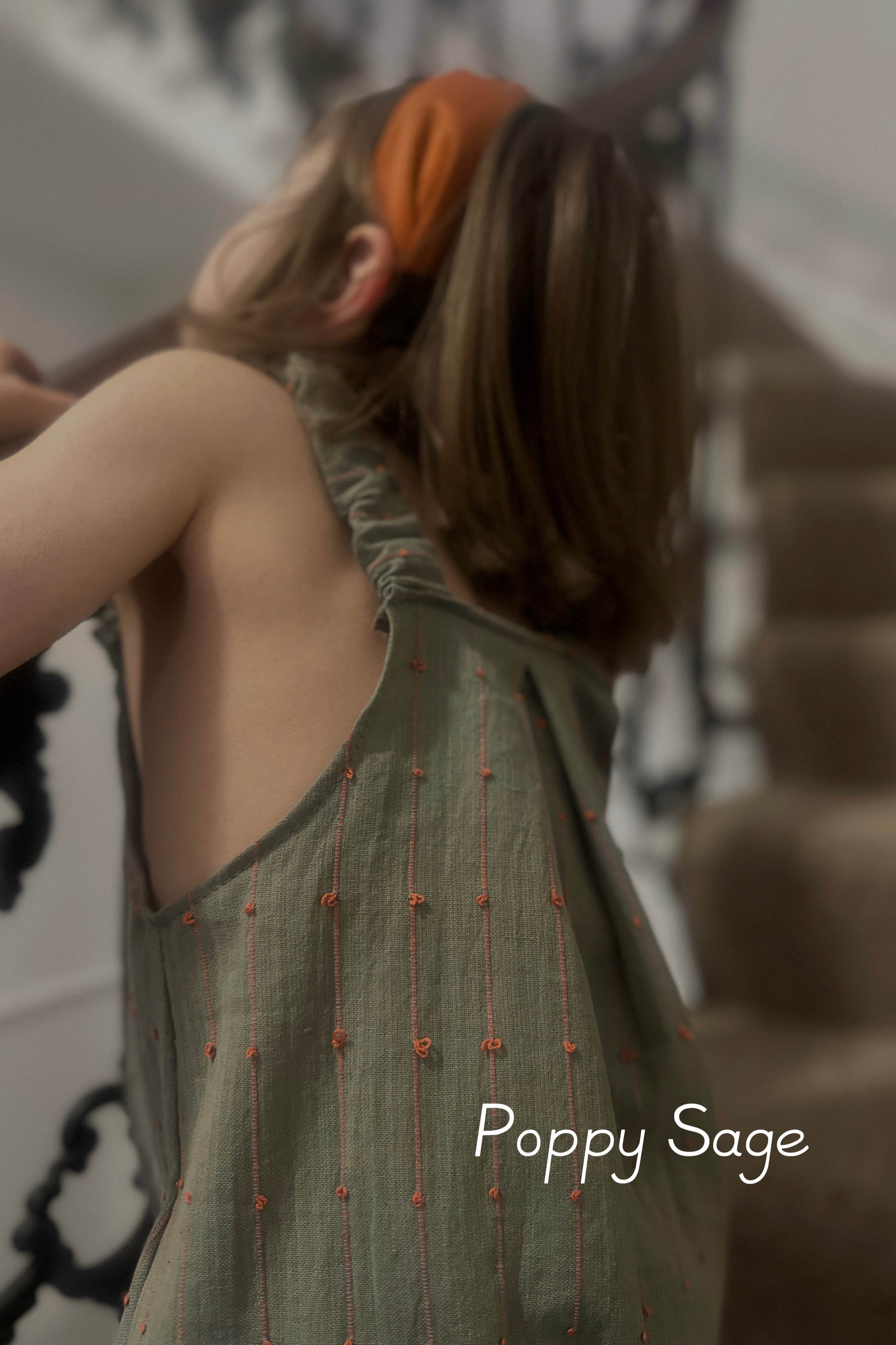 close up fabric of summer light cotton: dusty sage green with playful coral woven loops