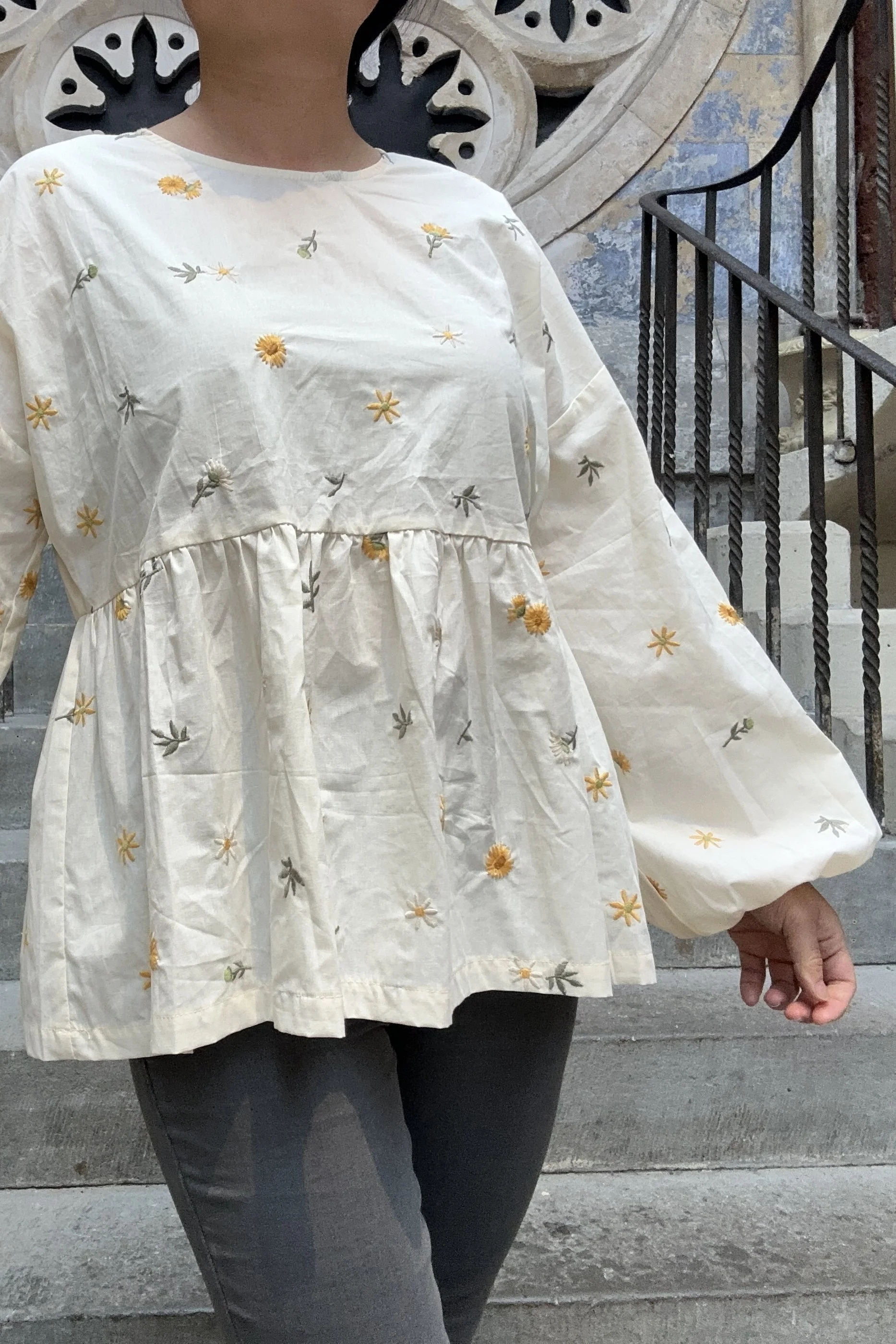 Adult wearing embroidered dandelions Top, Featuring a relaxed fit, balloon sleeves, paired with grey skinny jeans