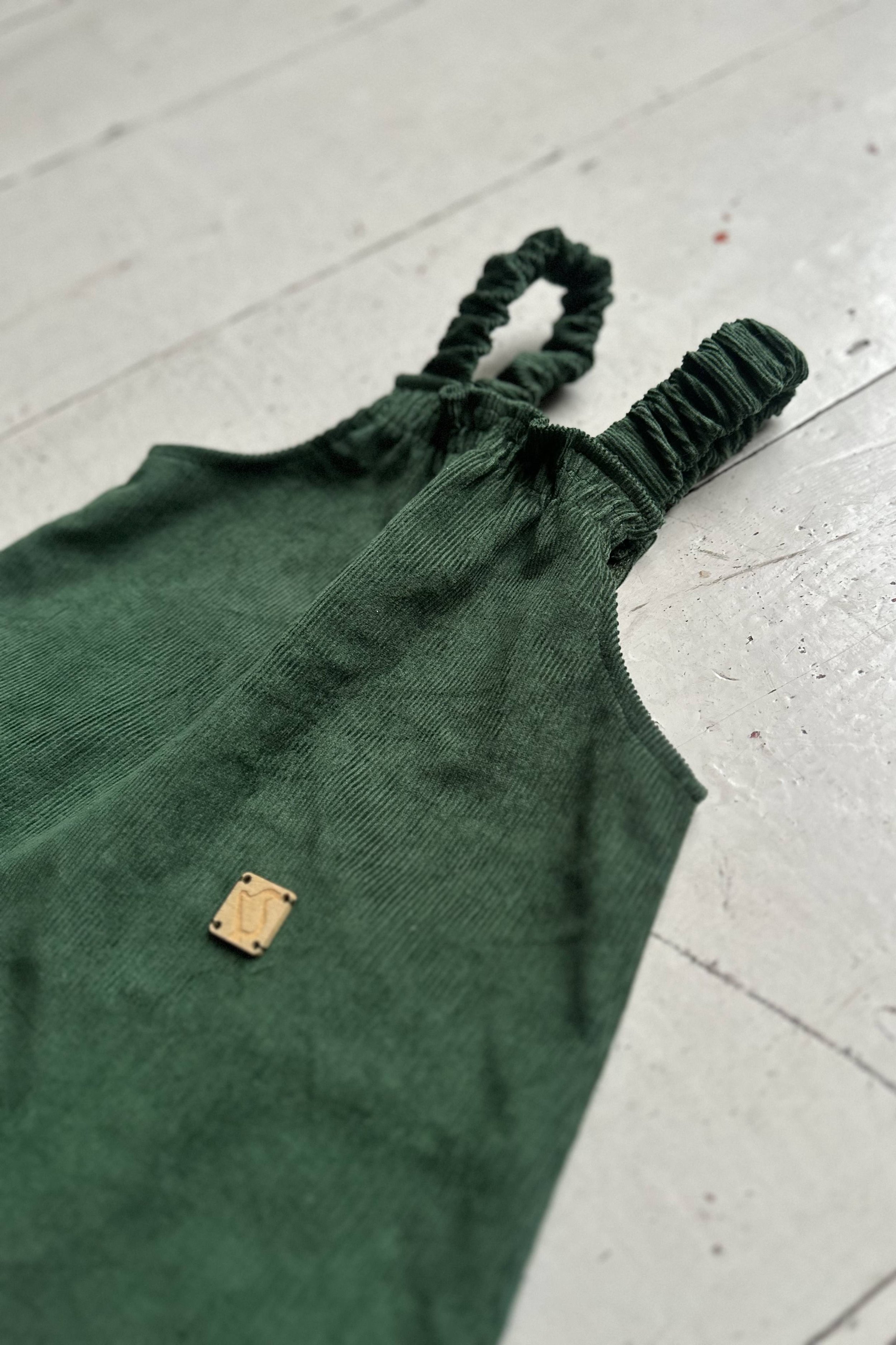 close up dark green organic needlecord pullover dungarees highlight elastic front