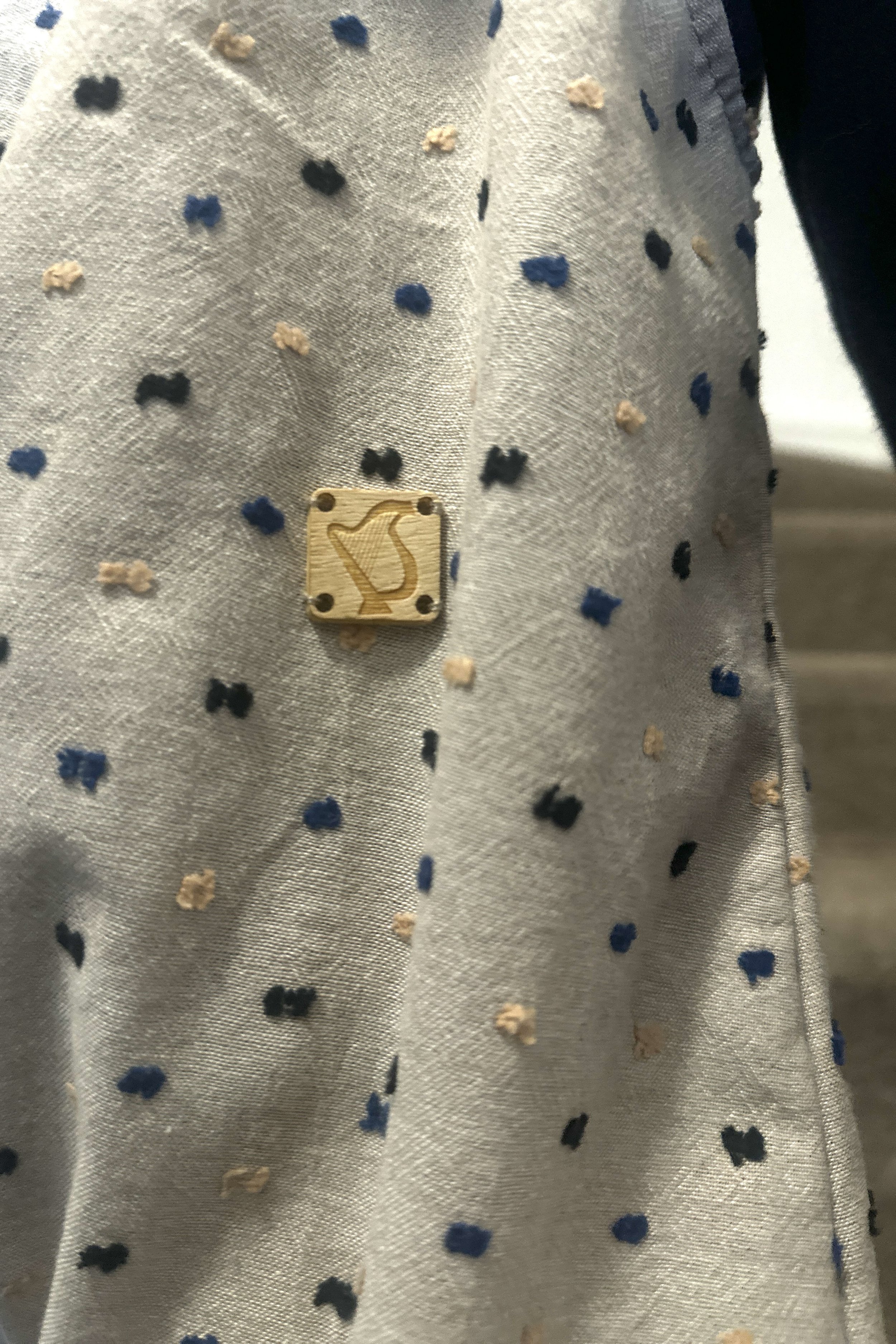 child wearing close up in details of organic cotton speckled dungarees Neutral colour