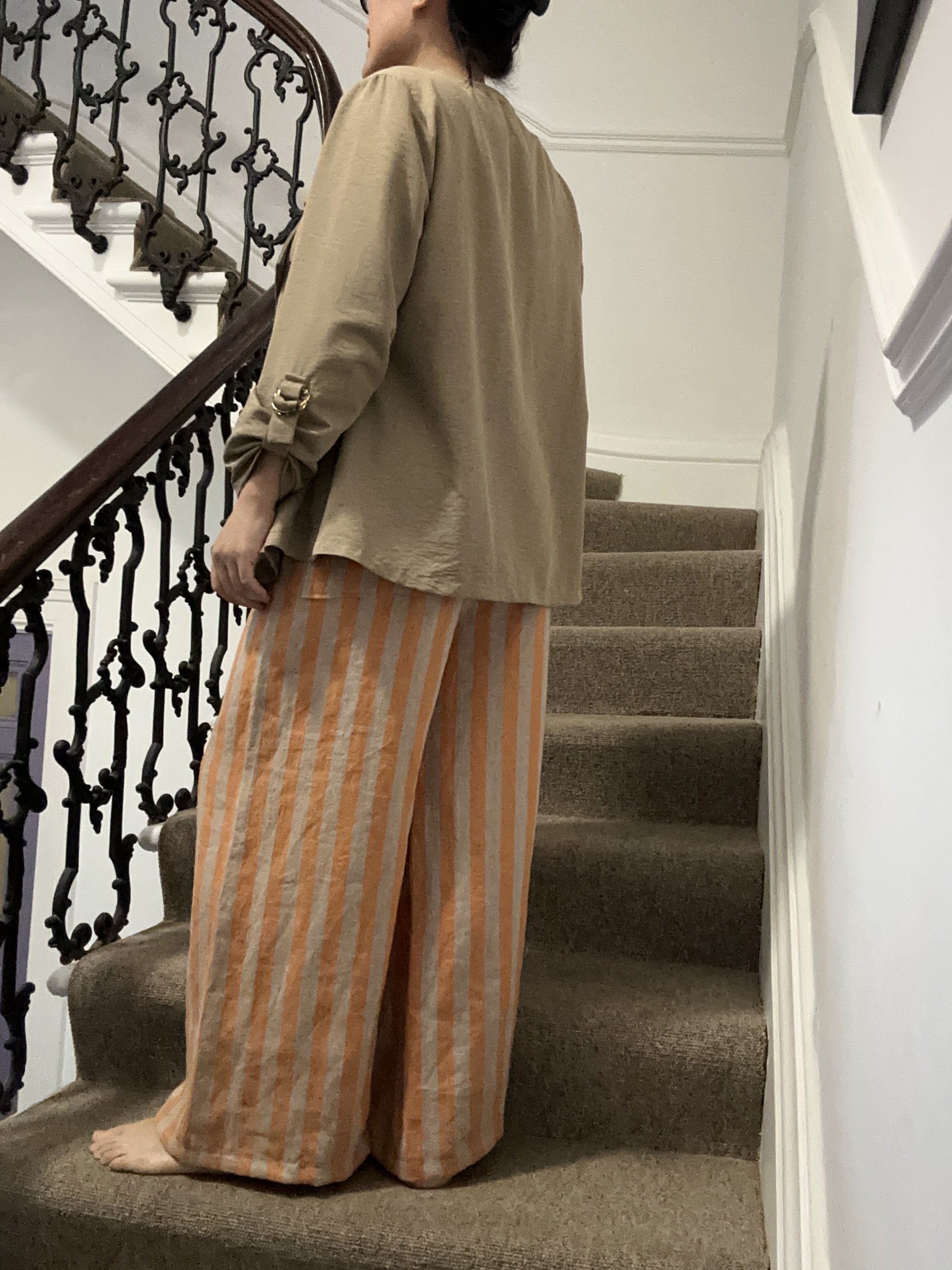 side view of Adult wearing Wide Leg Linen Trousers – Apricot & Beige Stripe, beige jacket