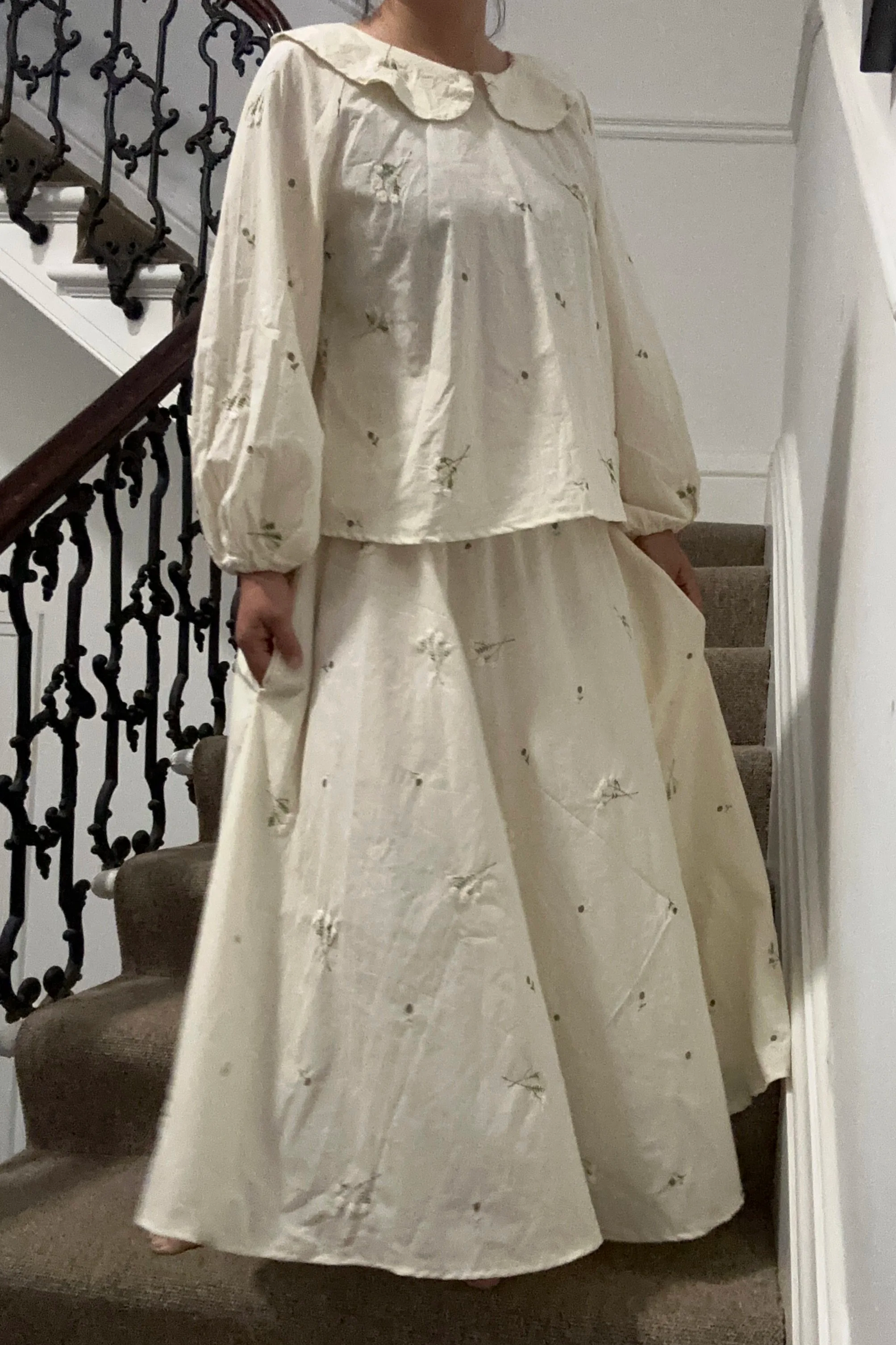 adult wearing organic cotton embroidery lace flower maxi skirt and blouse, standing on staircase