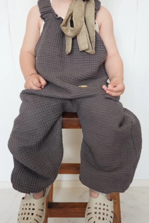 close up child wearing organic cotton waffle pullover dungarees charcoal, sun hat, scarf