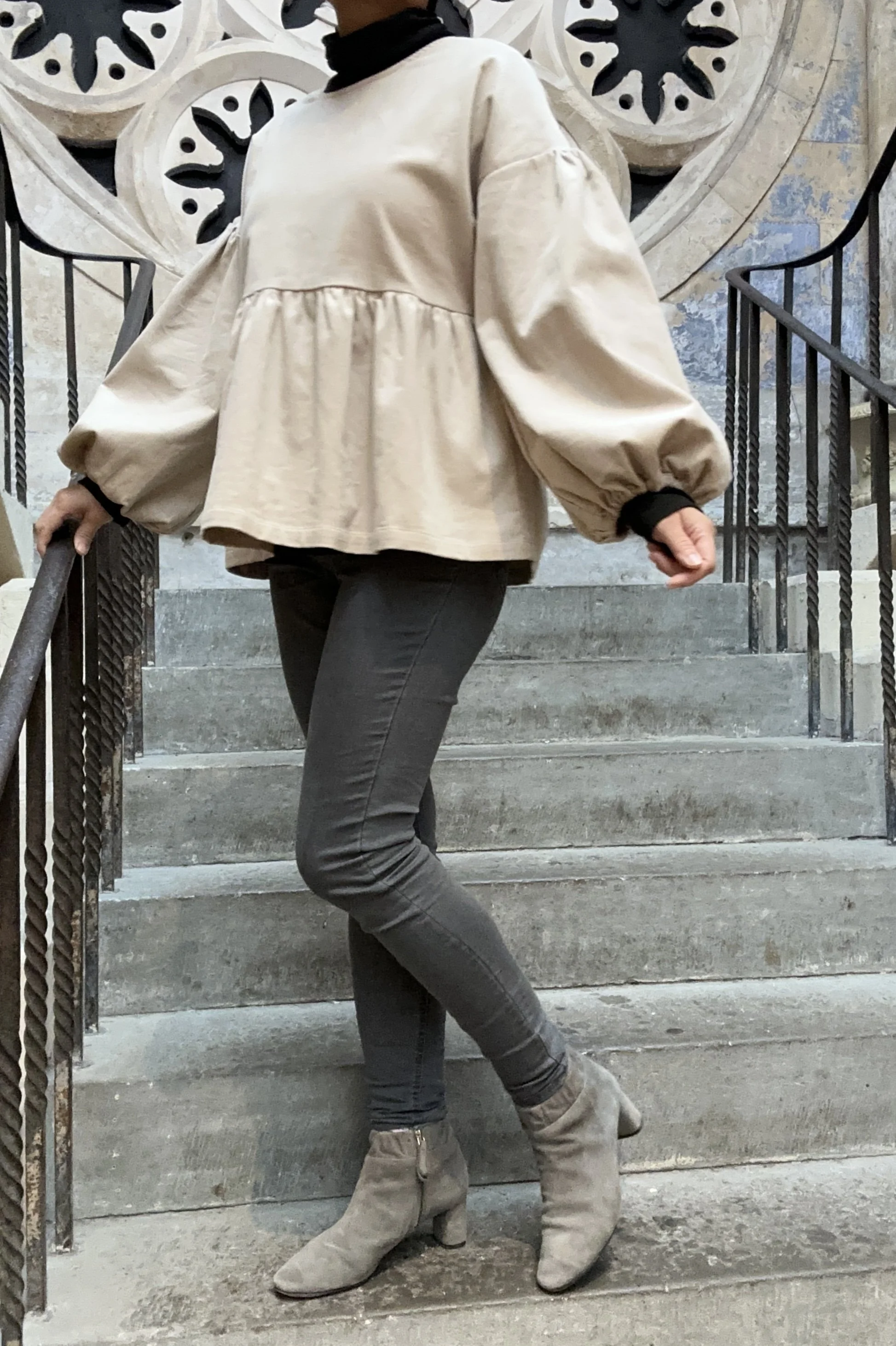 Adult wearing Latte Corduroy Top, Featuring a relaxed fit, balloon sleeves, paired with grey skinny jeans, and grey boots
