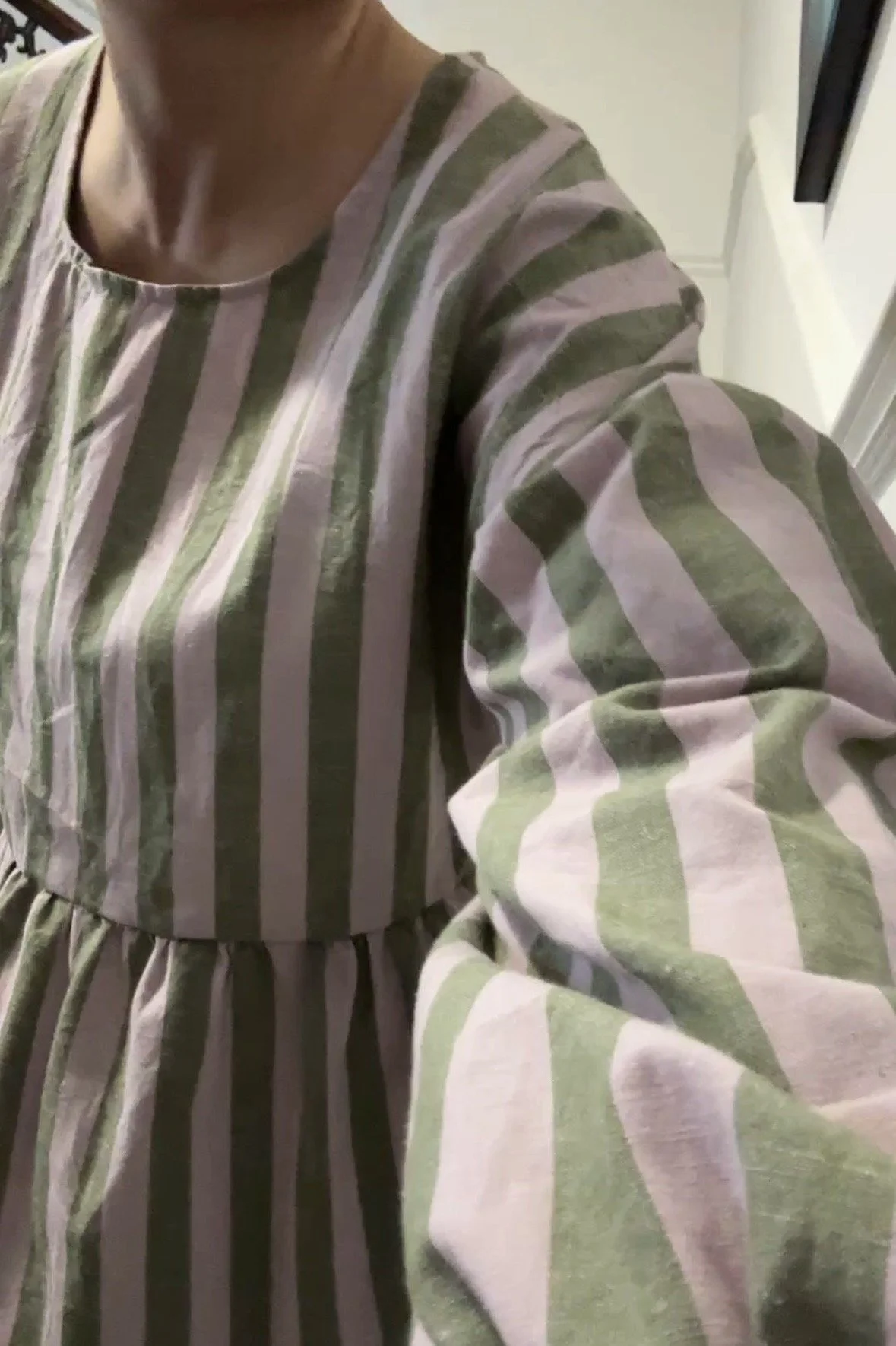 close up adult wearing organic cotton linen stripe olive green & lilac full length dress with balloon sleeves