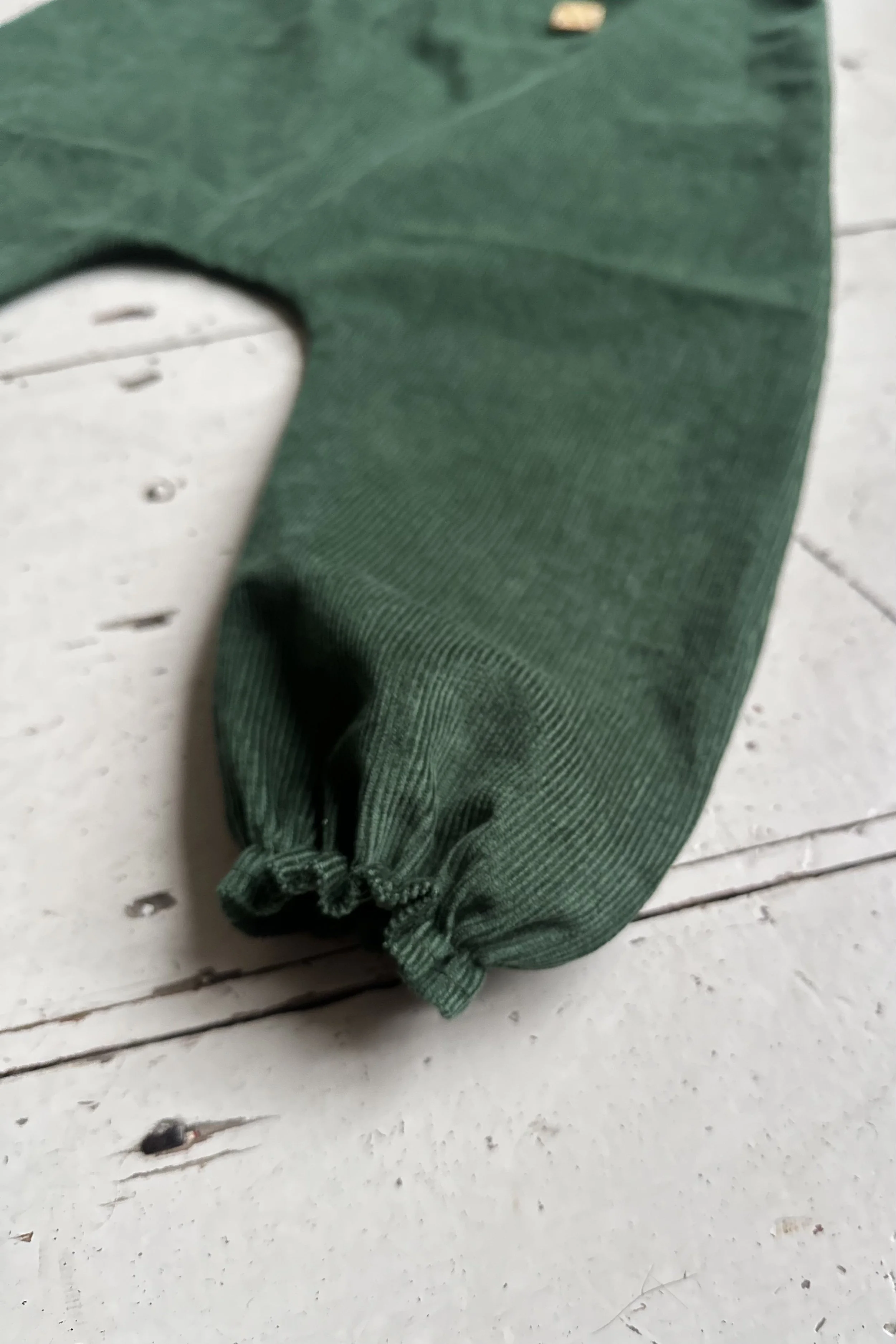 close up dark green organic needlecord pullover dungarees highlight elastic hem