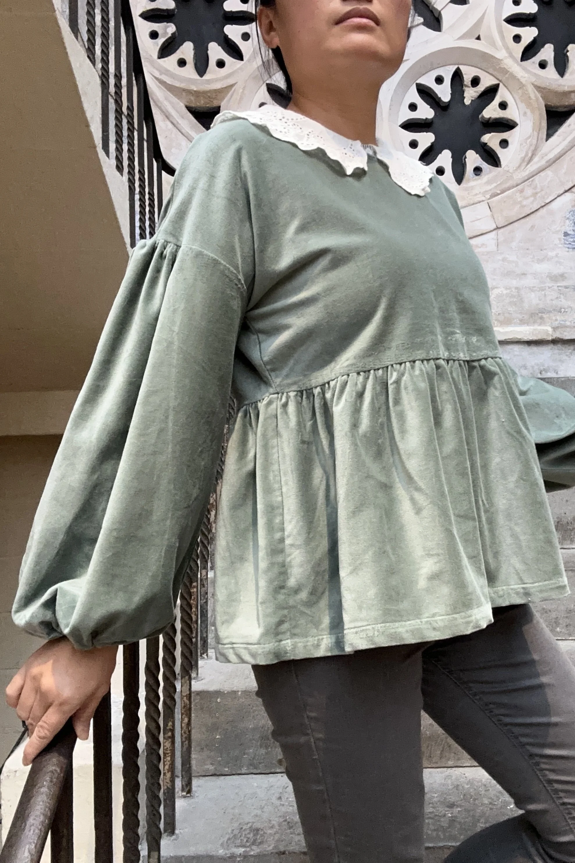 Adult wearing duck egg green-grey velvet Top, Featuring a relaxed fit, balloon sleeves, paired with grey skinny jeans