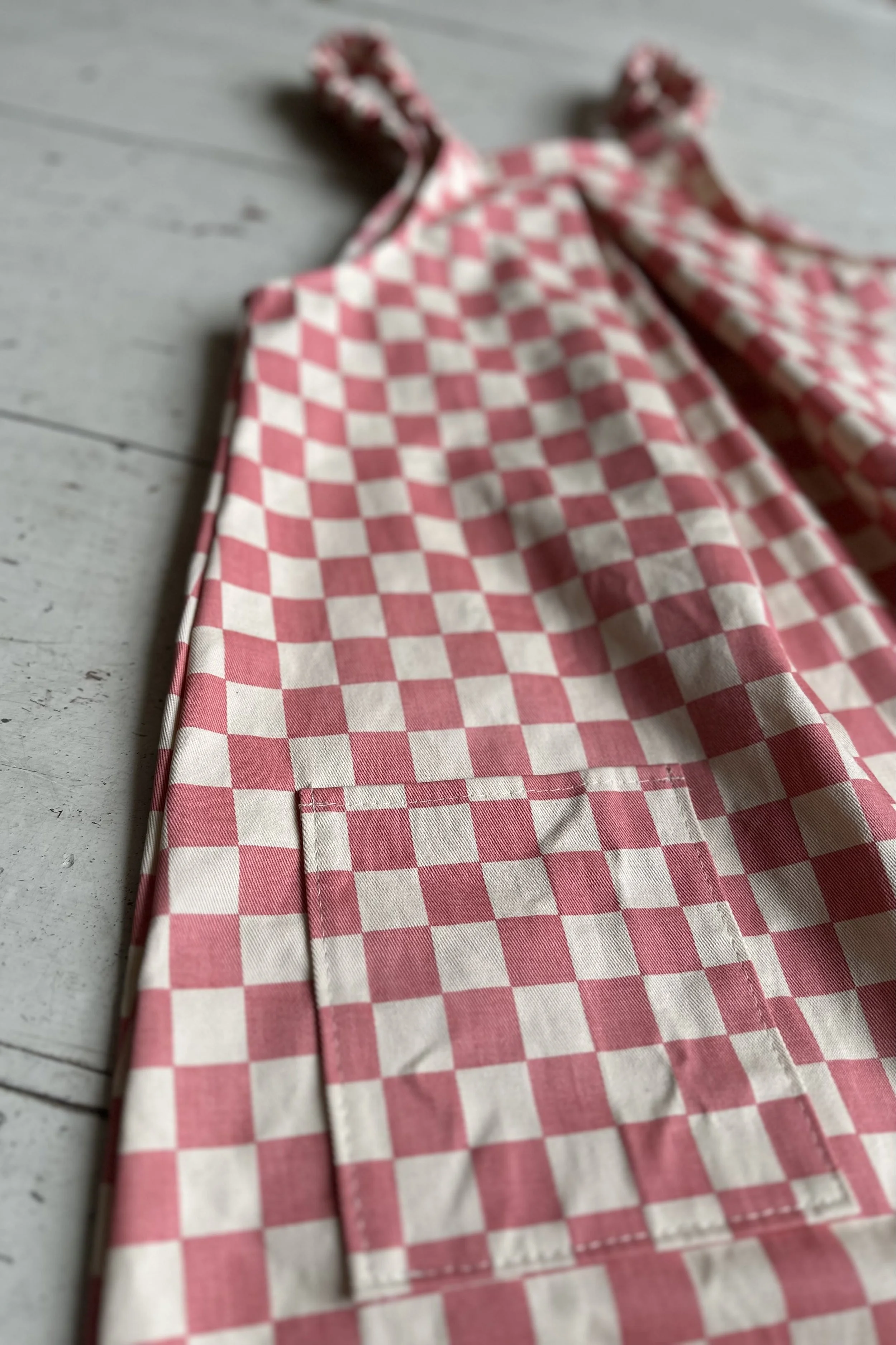 back view of child organic cotton pullover dungarees checkerboard pink, highlighting back pocket