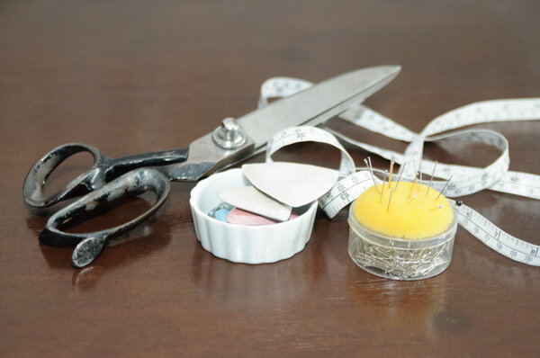 Brand photo of scissors, tape measure and chalk