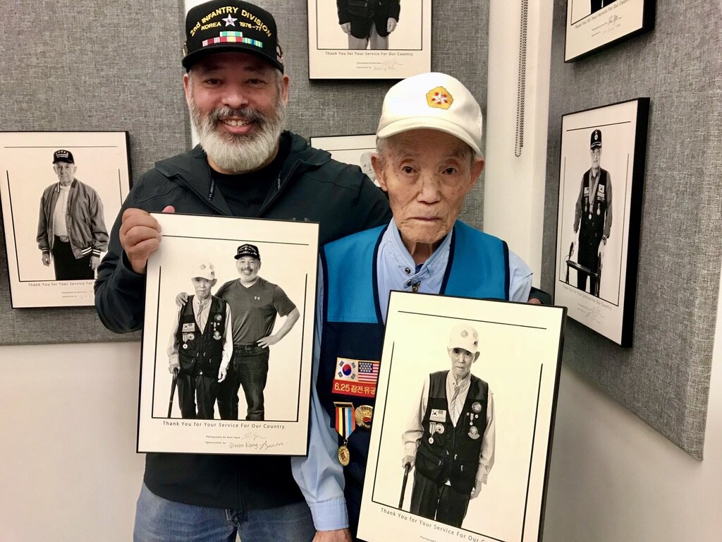  Korean War veteran Chung Ki Min, proudly shows his photo with his son-in-law David Penaflor. 