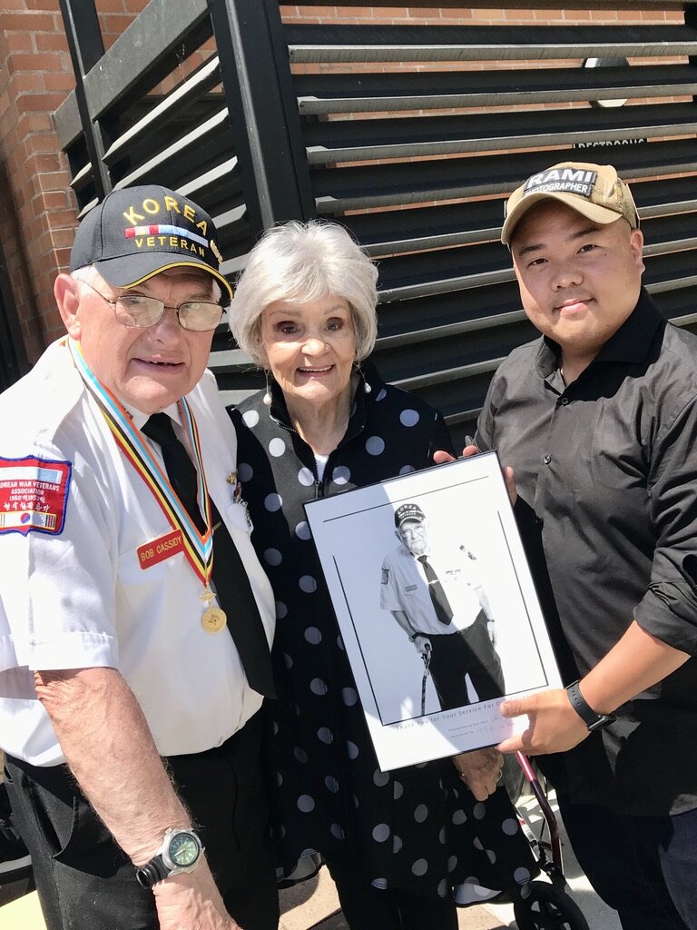  Bob Cassidy, former President of the KWVA Oregon Trail Chapter, receives his photo from Rami Hyun. Bob’s wife, Nikki, joins them. 