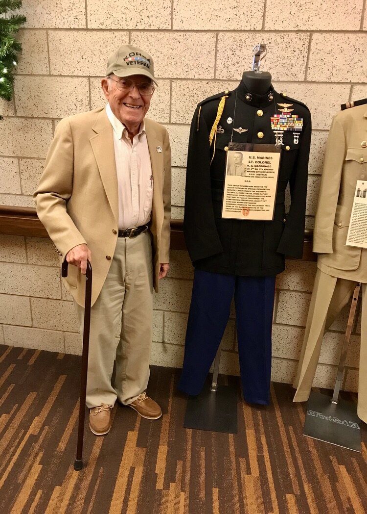  Ervin “Irv” Fletcher, a Korean War veteran and member of the KWVA/Oregon Trail Chapter, poses with uniforms from the Korean War. 