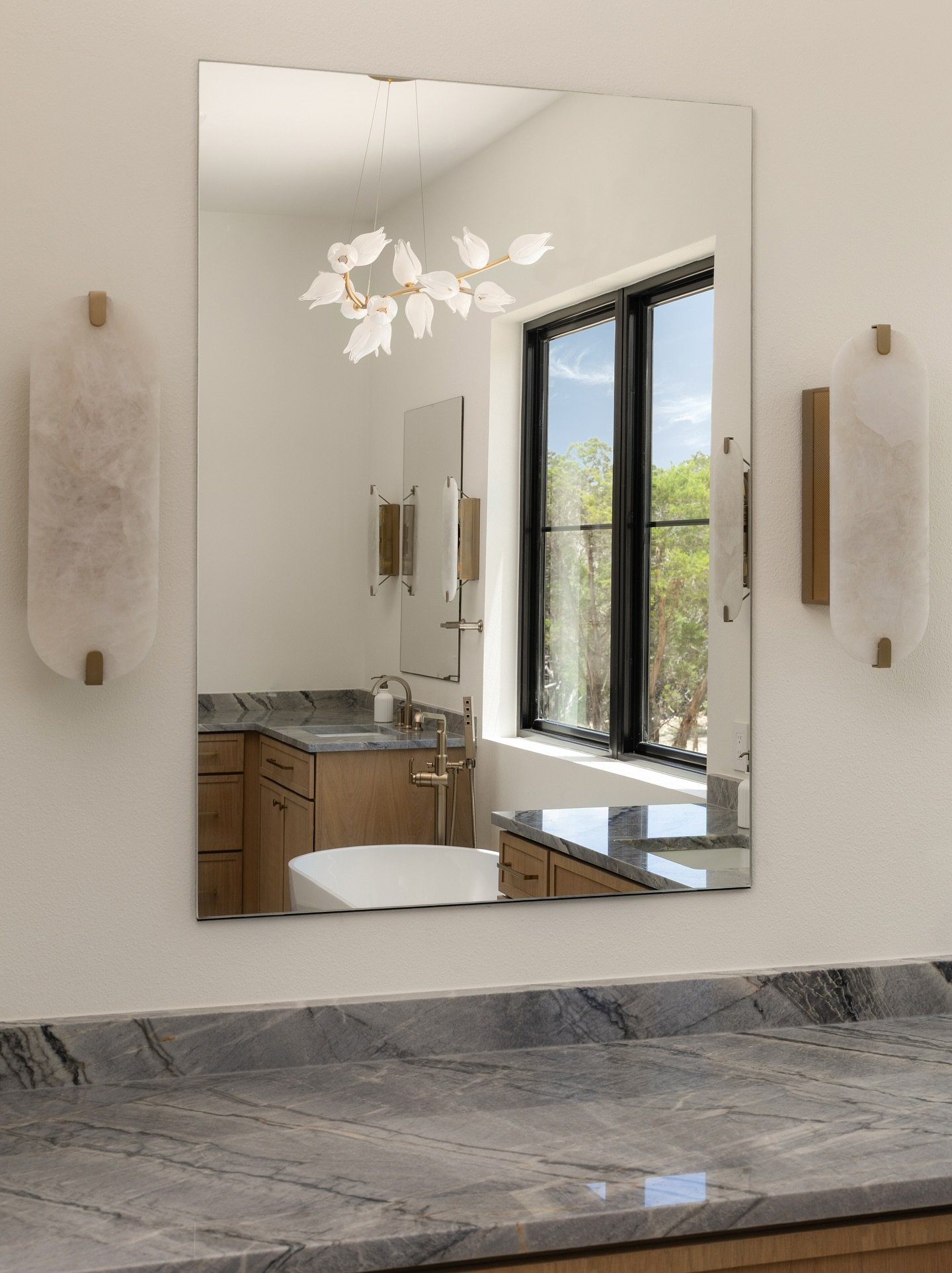 The primary bath at our #CircleDriveProject is layered with veined stone, warm oak, and brass details.  A retreat that feels calm, refined, and timeless. 

📸 @frankgarnicaphotography