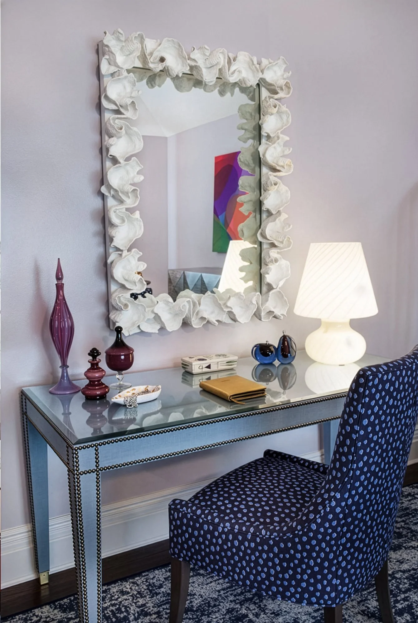 mirrored desk with chair and decorative mirror abov