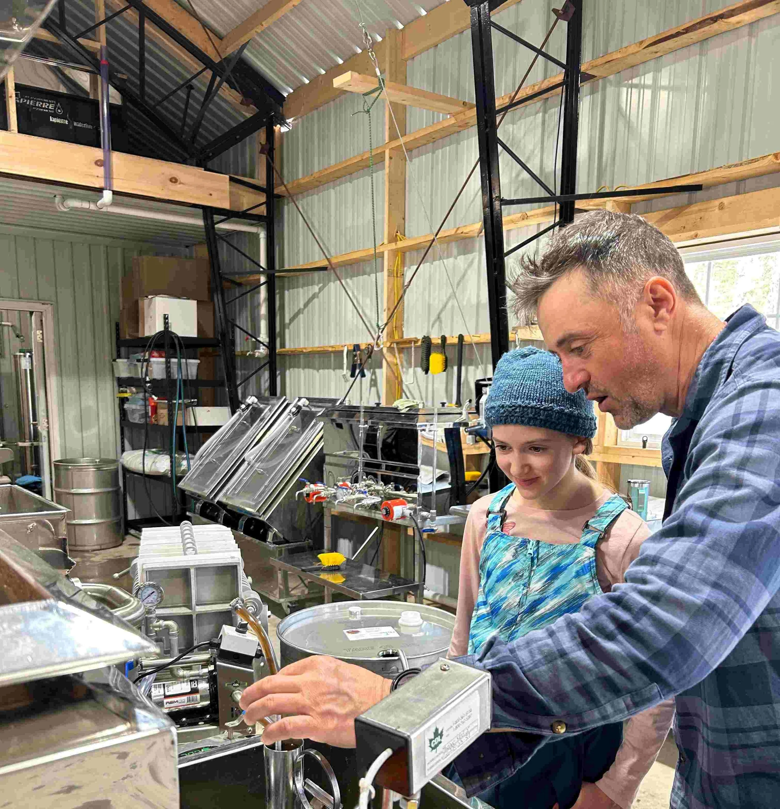 Wild Woods Maple owner Rob teaching the next generation of syrup production how to check density with a hydrometer.