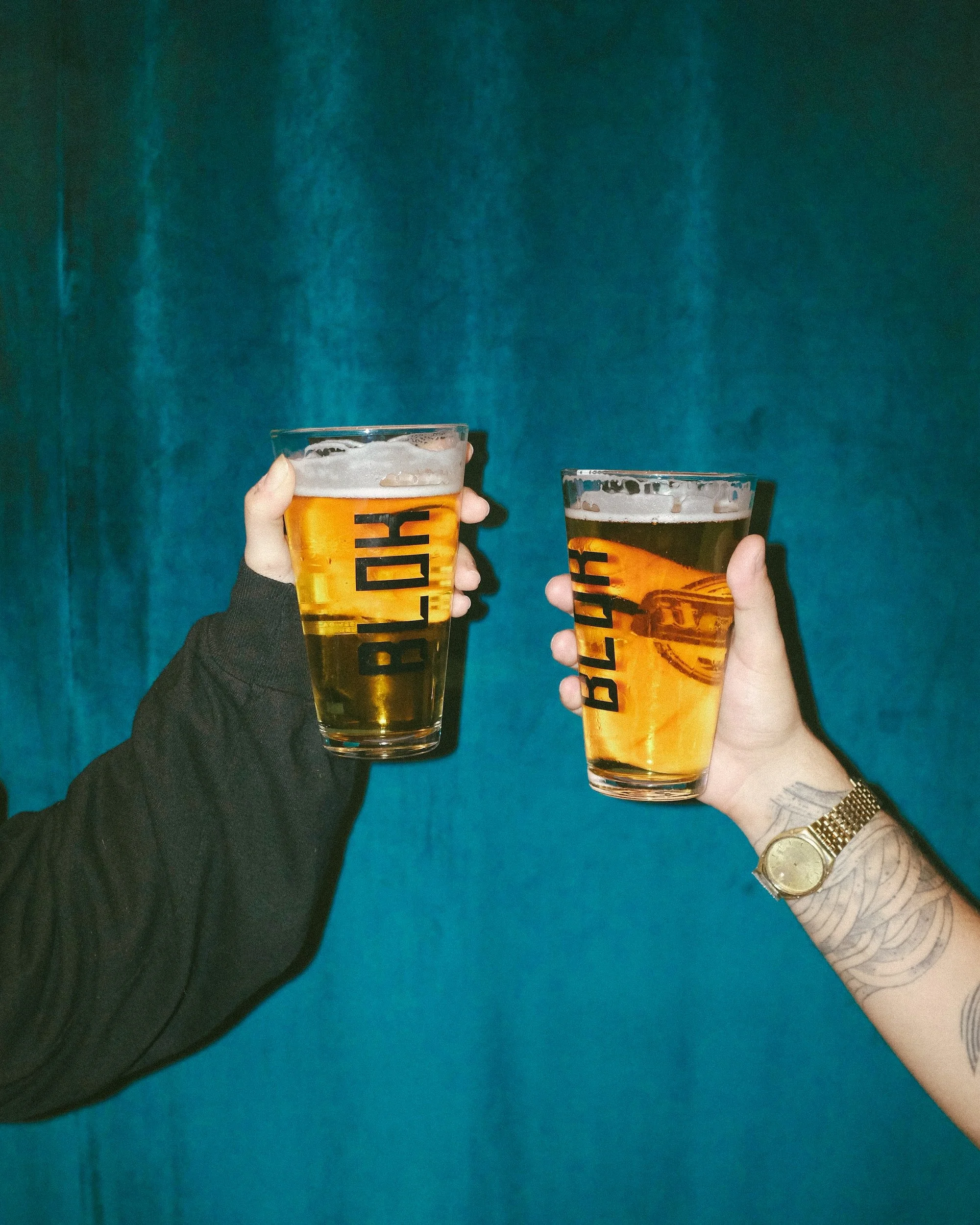 Two people holding beers and saying cheers