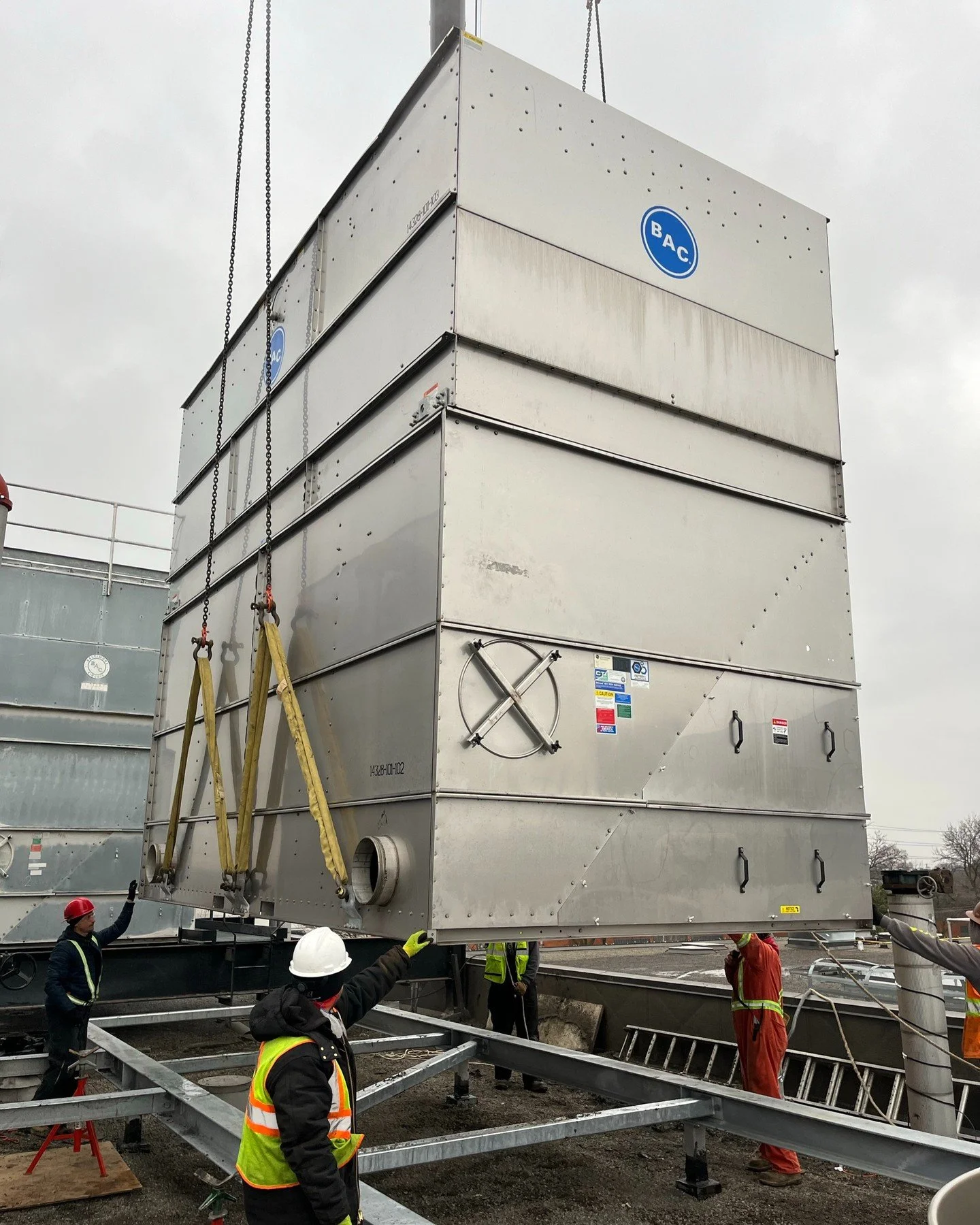 A huge cooling tower unit being carefully lowered with the help of our skilled technicians. With everyone focused and working together, we make even the toughest tasks look easy. It’s all about teamwork, precision, and getting the job done righ