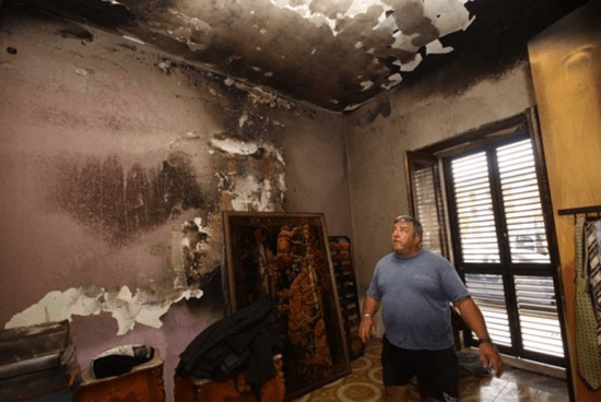 A man examines the damage left behind by one of the mysterious fires