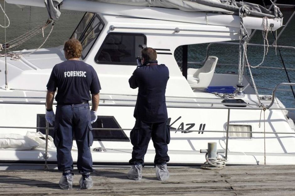 A forensic team of police officers examine the abandoned yacht