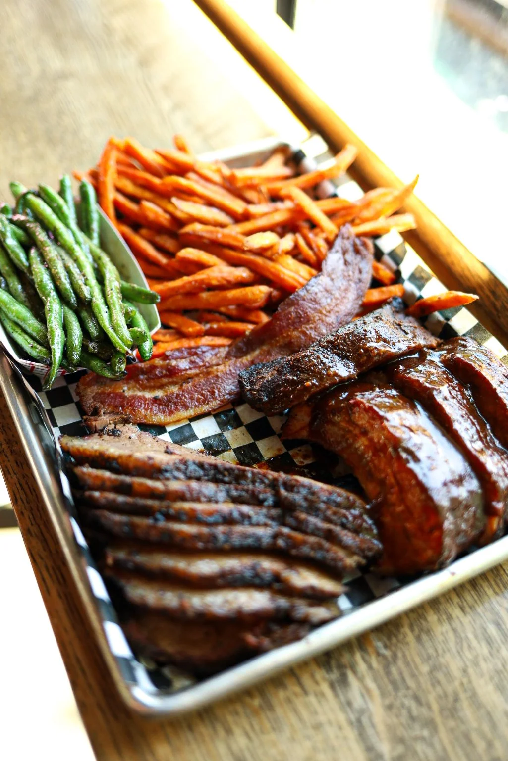 Platter with ribs, brisket, bacon, green beans and sweet potato fries