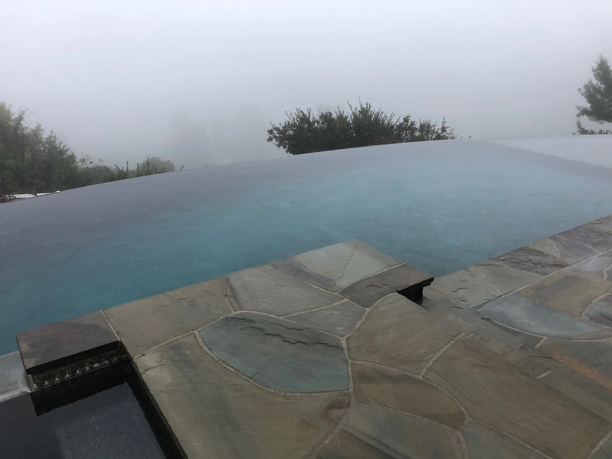 Salt infinity pool and spa combo with equipment below level.