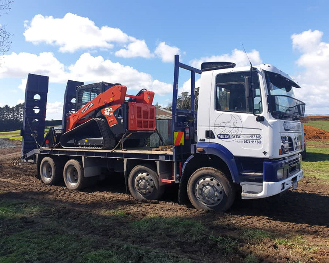 kubota skid steer on back of transporter