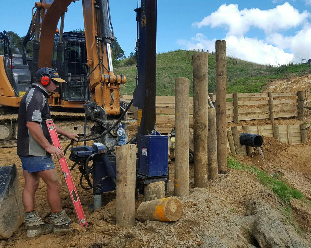 excavator with revolution post driver driving in a post
