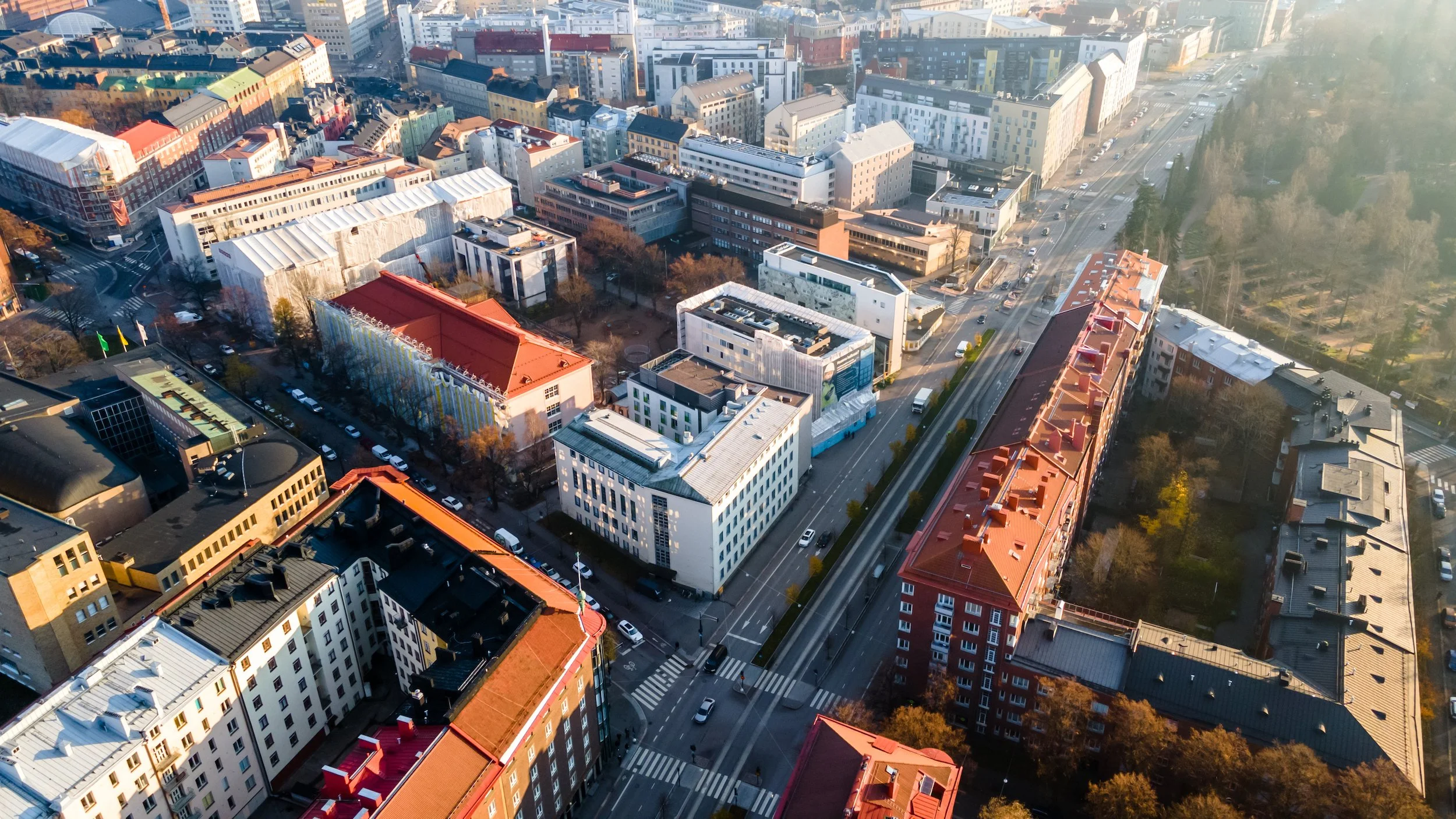 Korkealta otettu kaupunkinäkymä, jossa on monenlaisia rakennuksia ja teitä, sekä katuja liikenteessä.