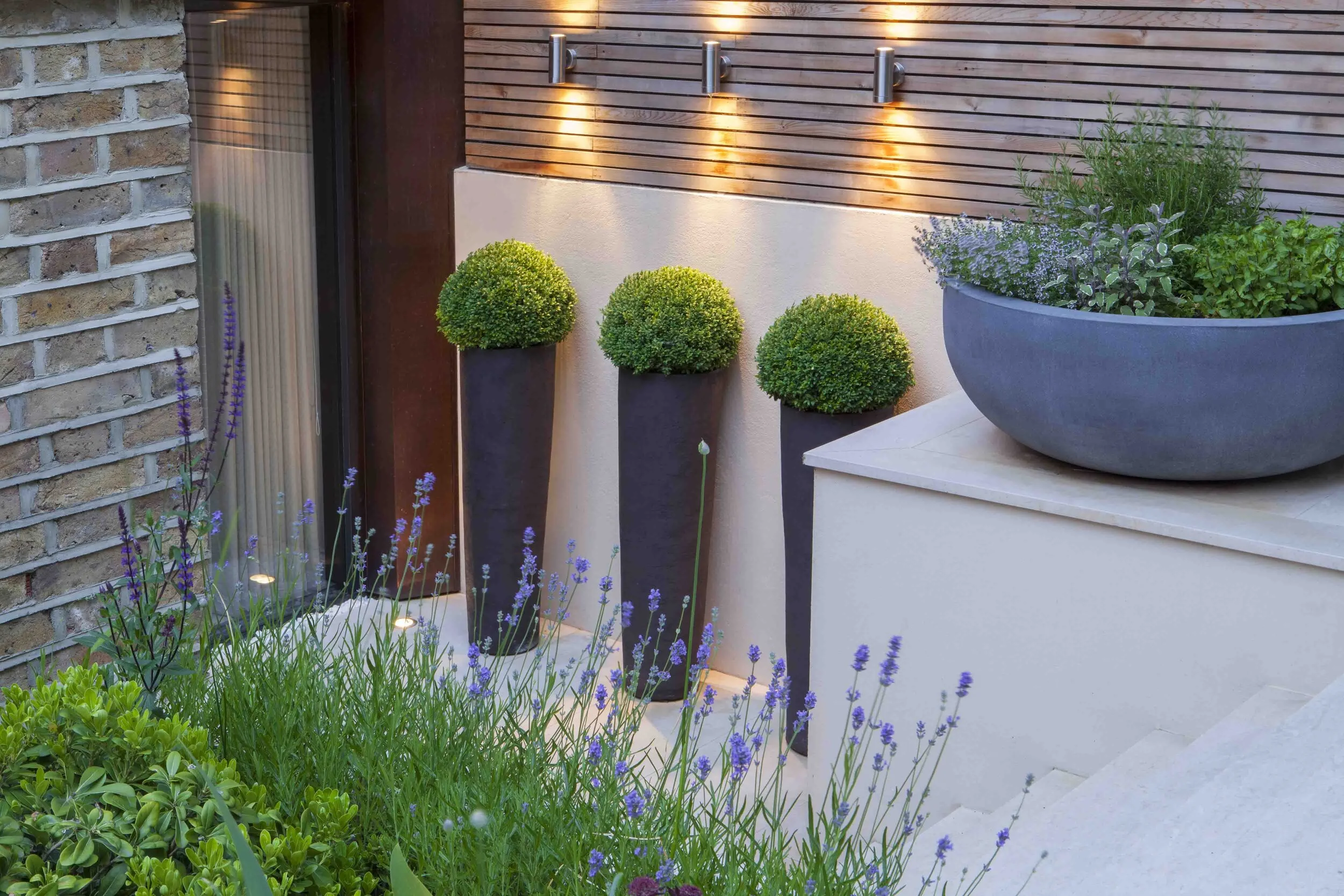 Town garden London terrace lighting cream limestone planters culinary herbs Charlotte Rowe Marianne Majerus