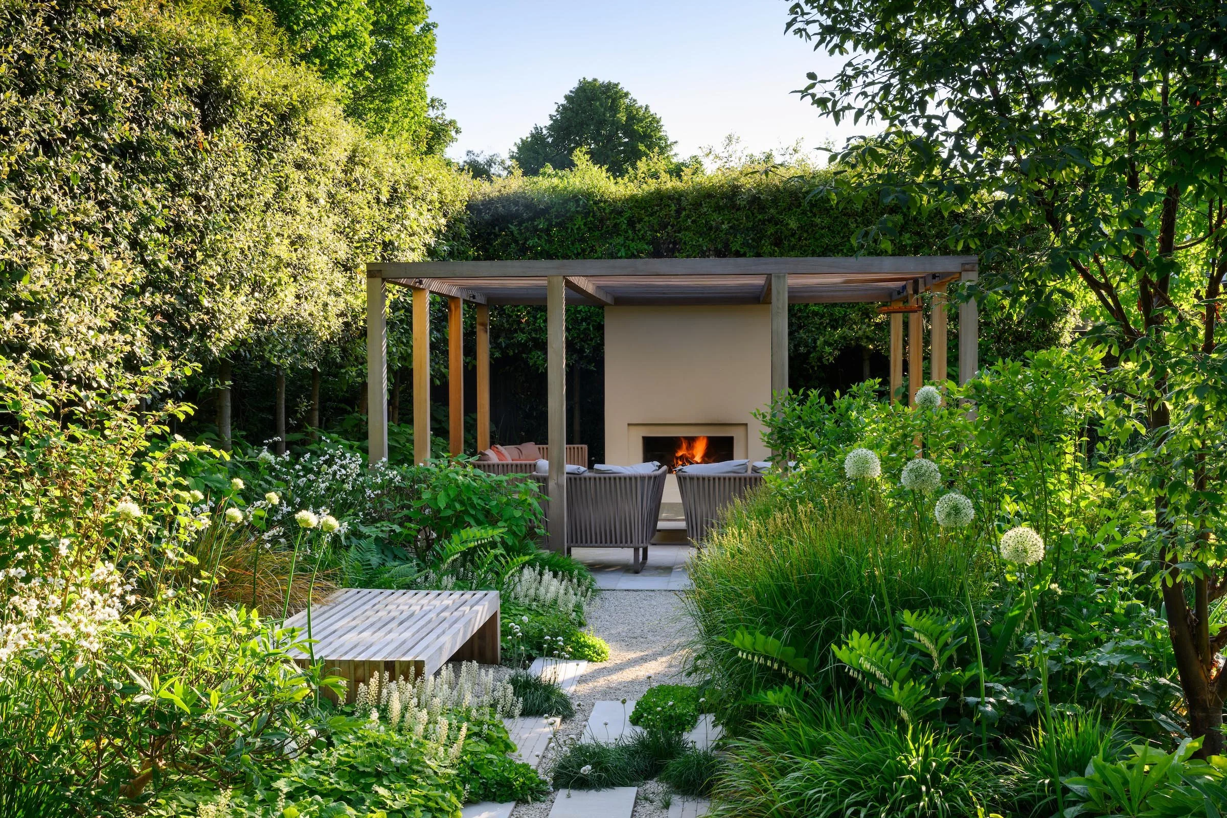 Rear garden in Putney with ramped gravel and limestone steps leading up to planted beds