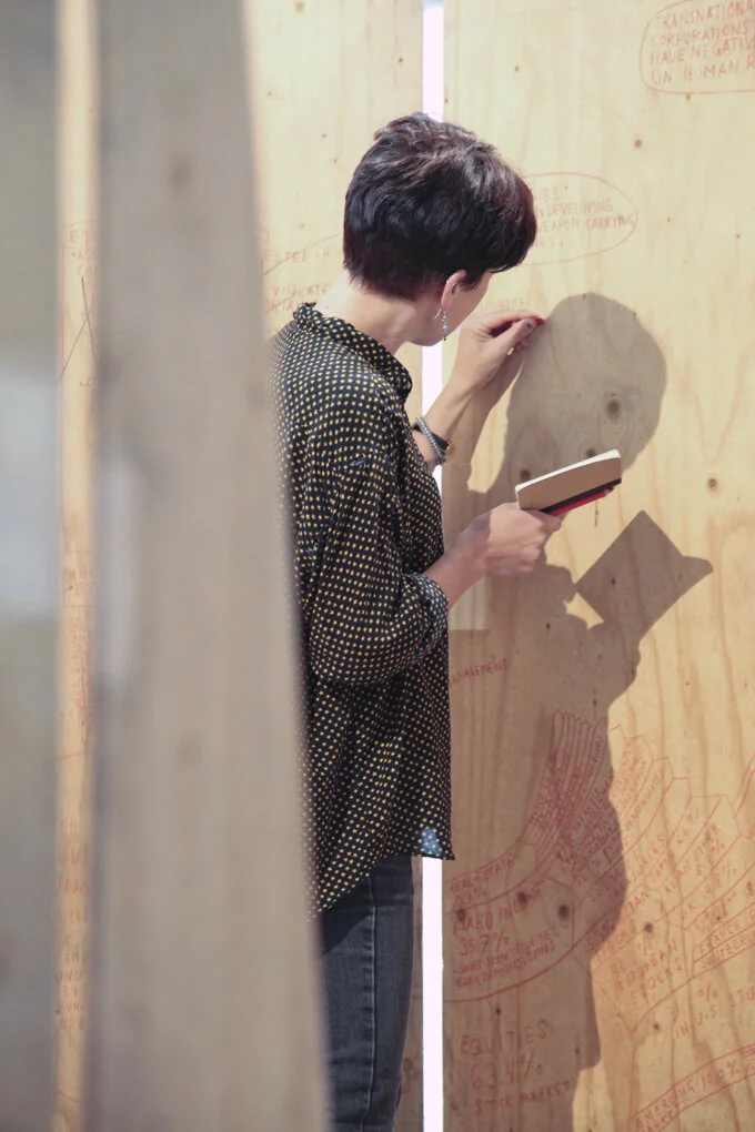 Minna Henriksson tegner verket på gamle finerplater fra Romsås T-banestasjon. Romsås senter, 2013. Foto: Una Hunderi