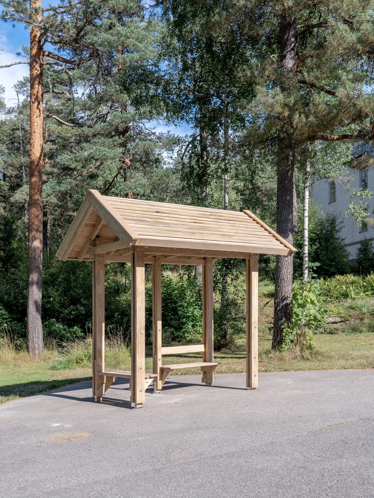 "Kommunal kontruksjon: fra venteplass til møteplass (paviljong formet etter Askers busskur, bygget i ask fra Asker, med dobbel benkeplass)" av Karsten Larsen