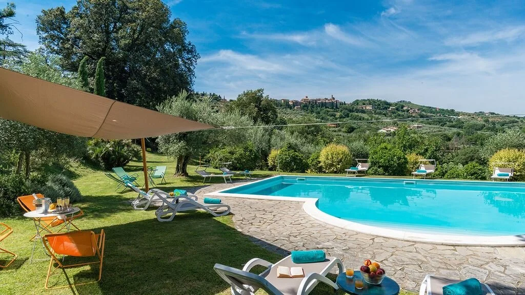Villa LeMura pool with sun loungers and Tuscan hills