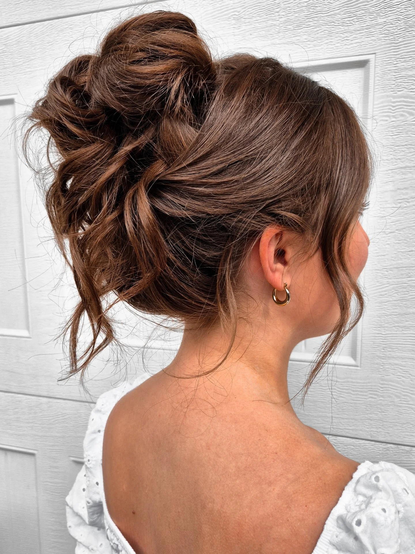 Every wedding season brings new trends. Sometimes subtle, sometimes bold. High updos have always been a classic, but one of the biggest changes in recent years is how the front is styled and swooped back, connecting under the bun instead of on top. T