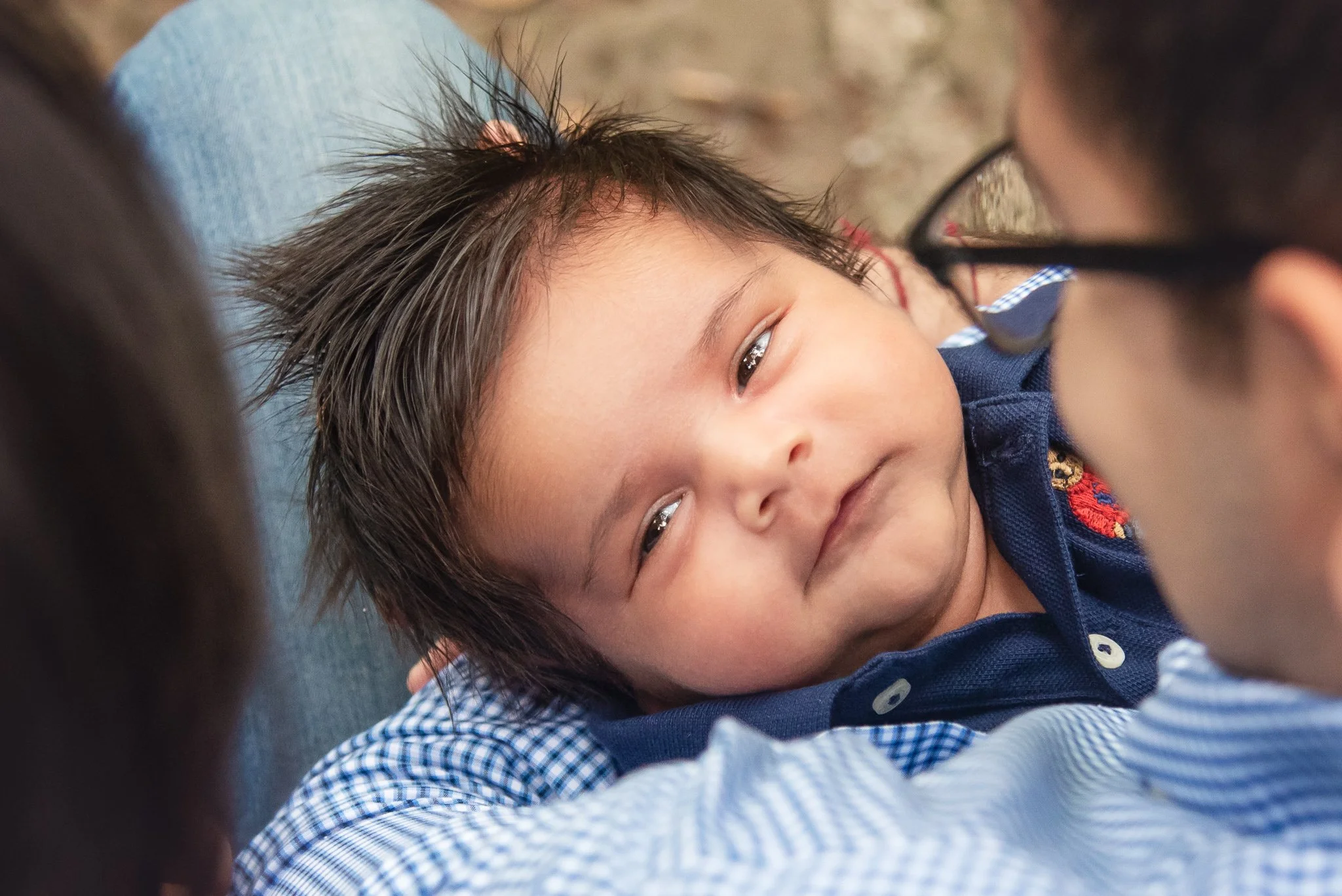 baby in dad's arms looking lovingly up at mom in a family photo session