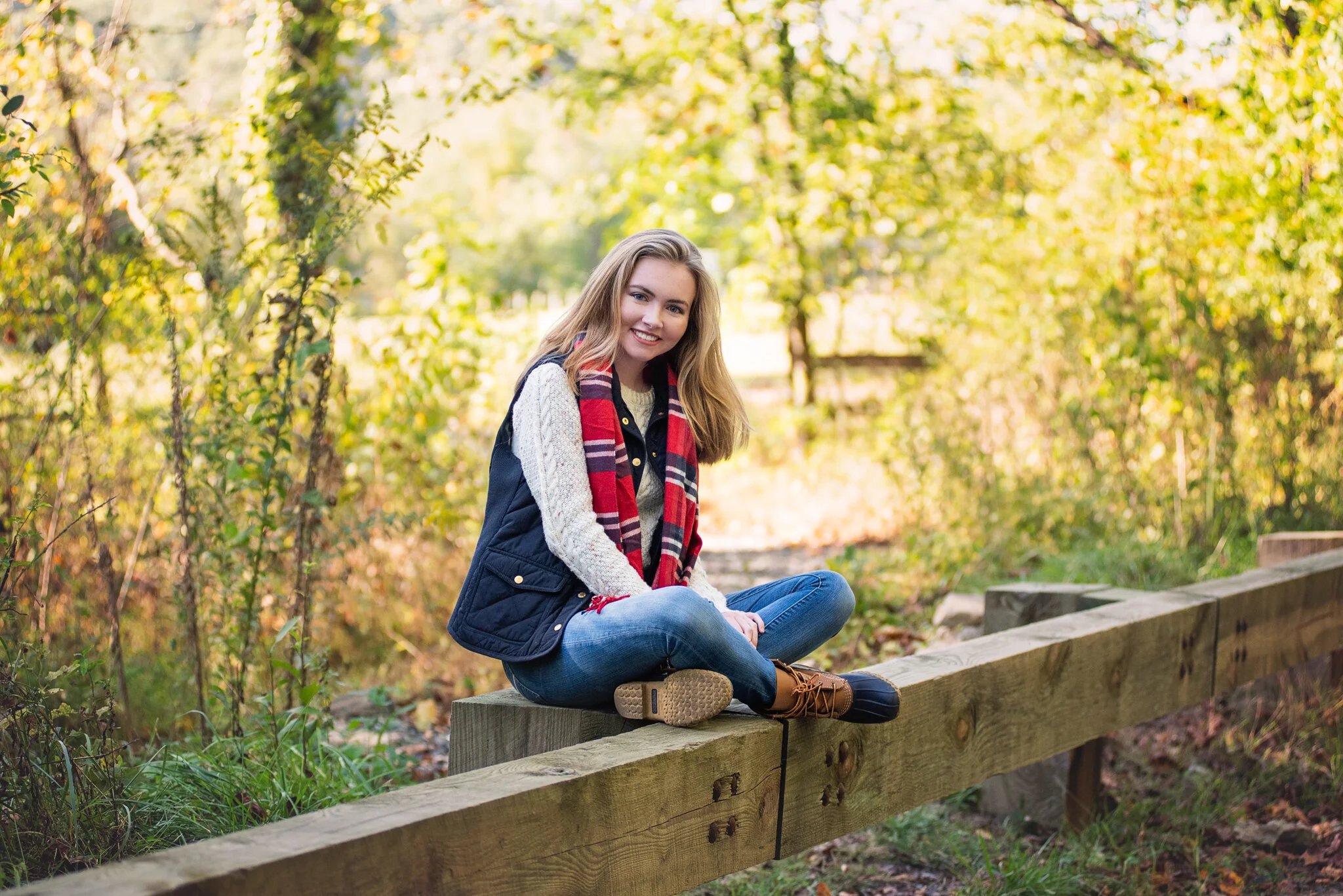 senior casually seated in jeans and sweater