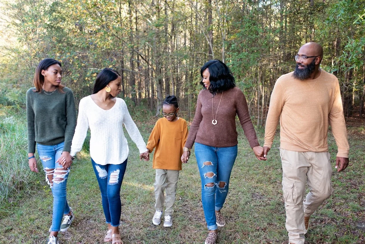 Family walking together for photo session in Marvin Efird Park