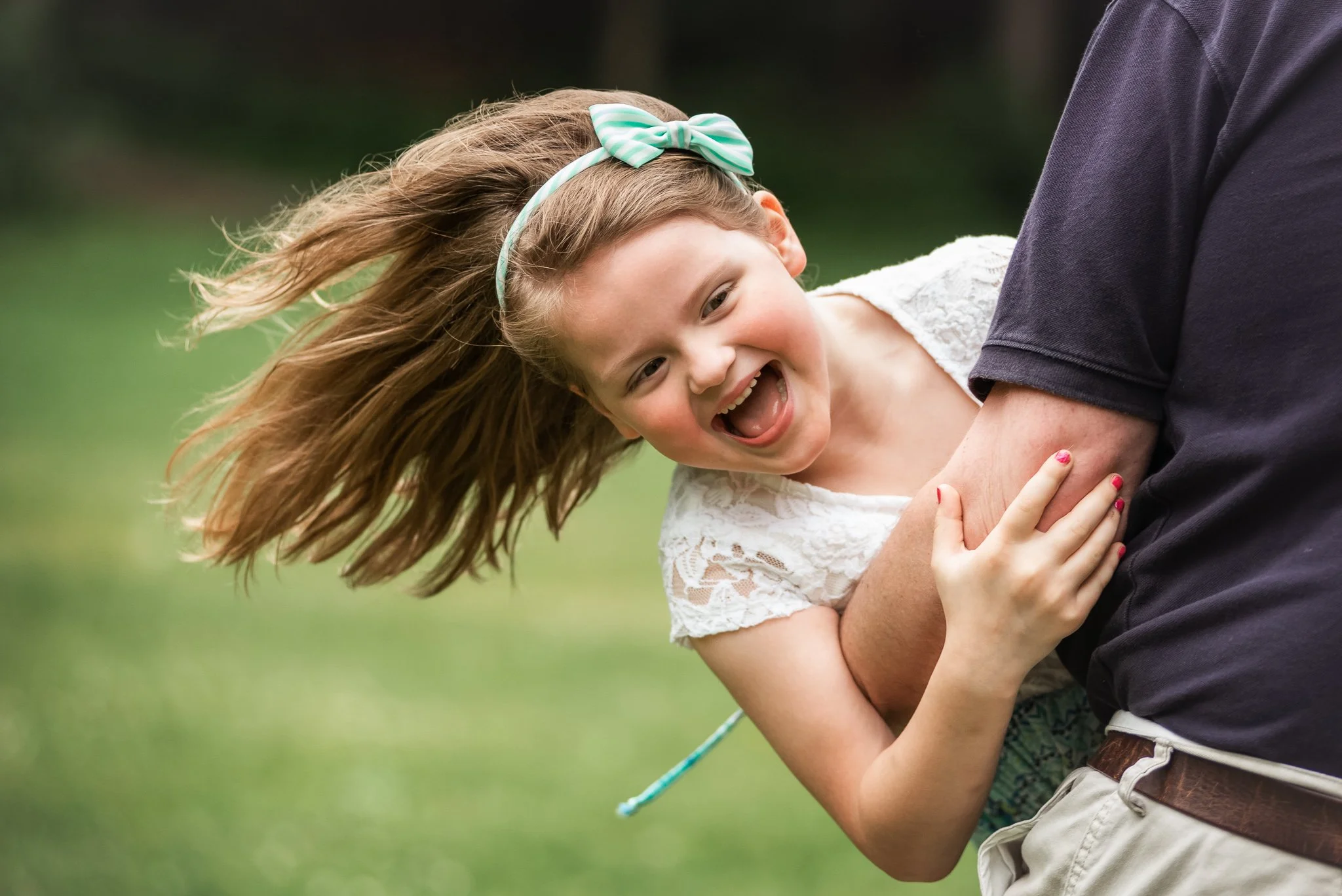 daughter playing and laughing with dad at a family photo session