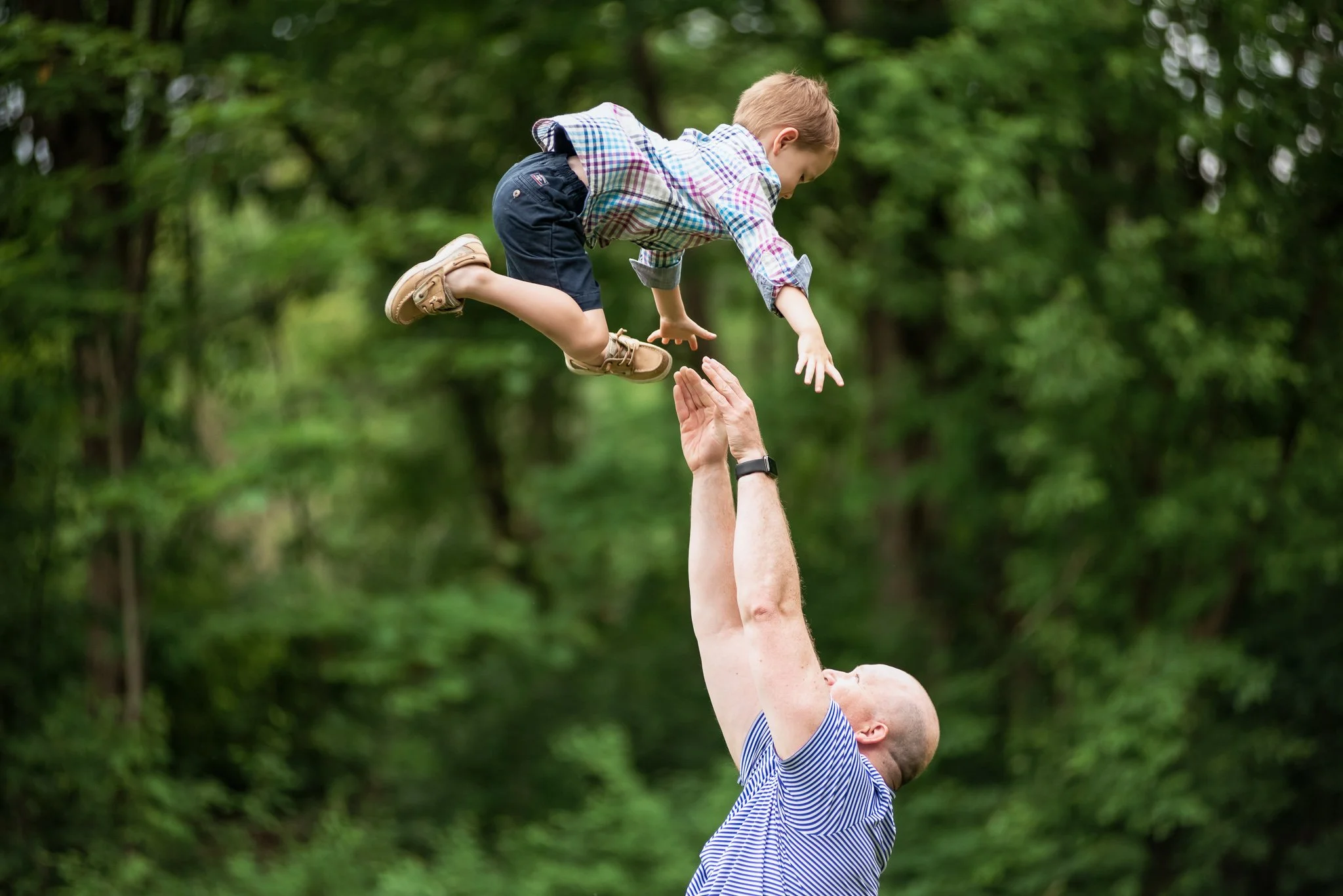 dad throwing kid up in the air during family photo session, charlotte, nc